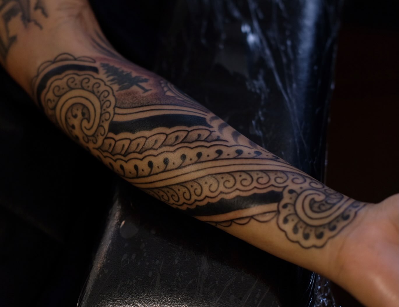Wave and cloud black and grey tattoo on the forearm by Owlyn Madrone