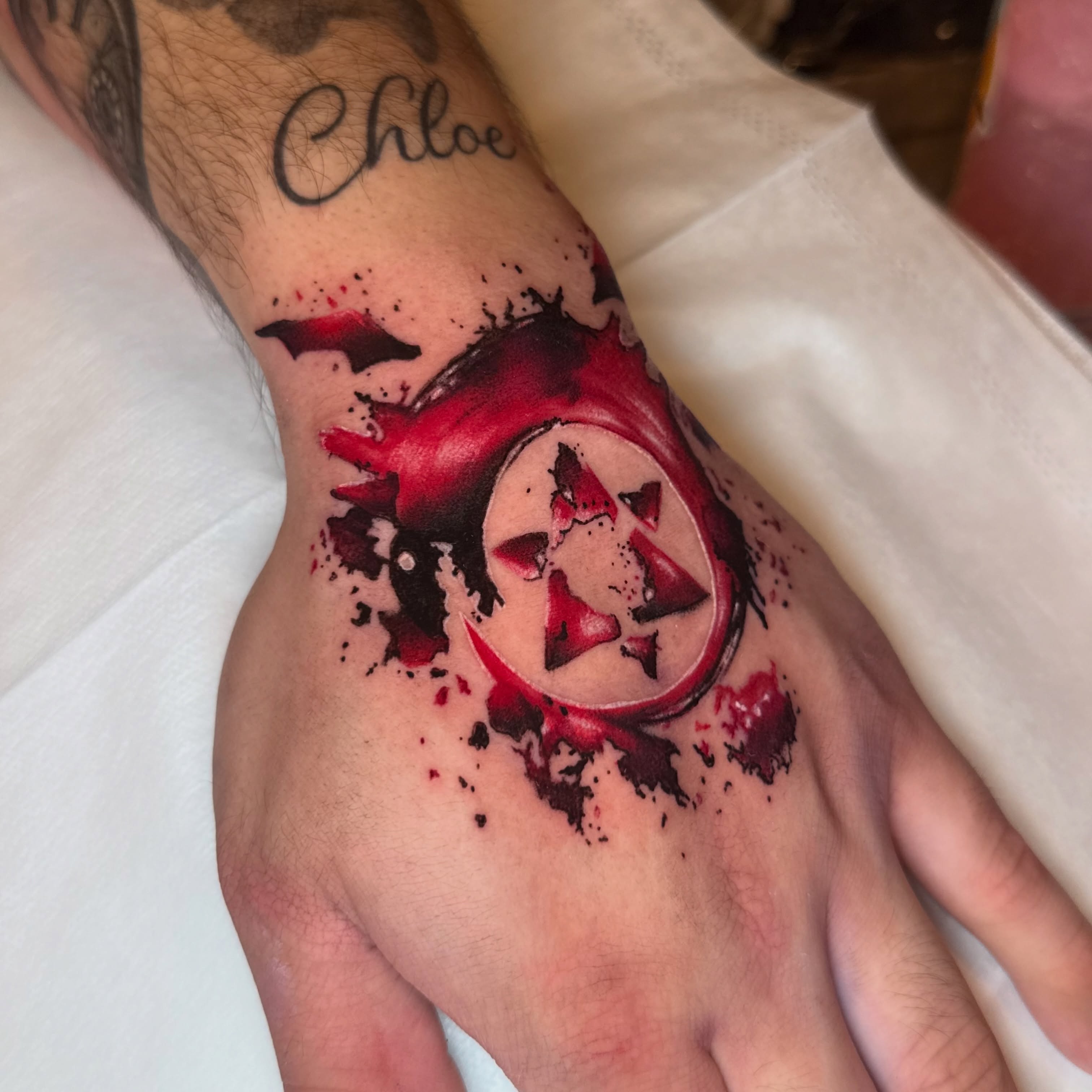 Red star and splatter dotwork tattoo on the hand by Alexia