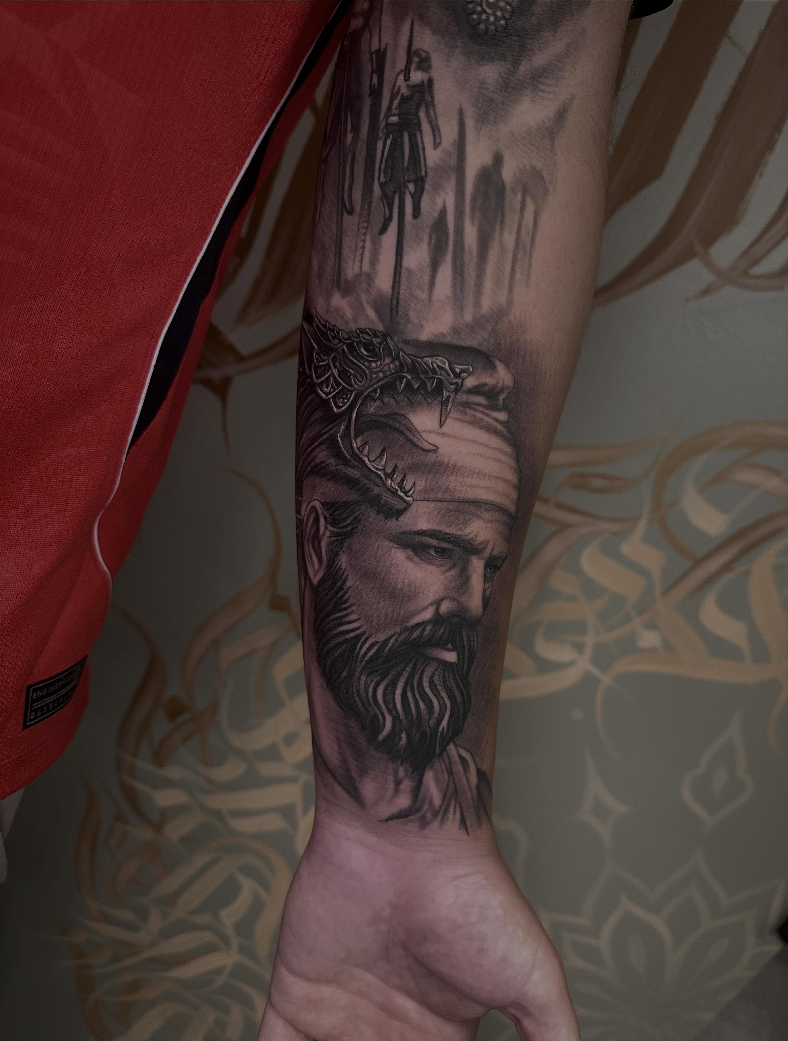 Bearded man with dragon helmet realism tattoo on the forearm by Javier Rivera