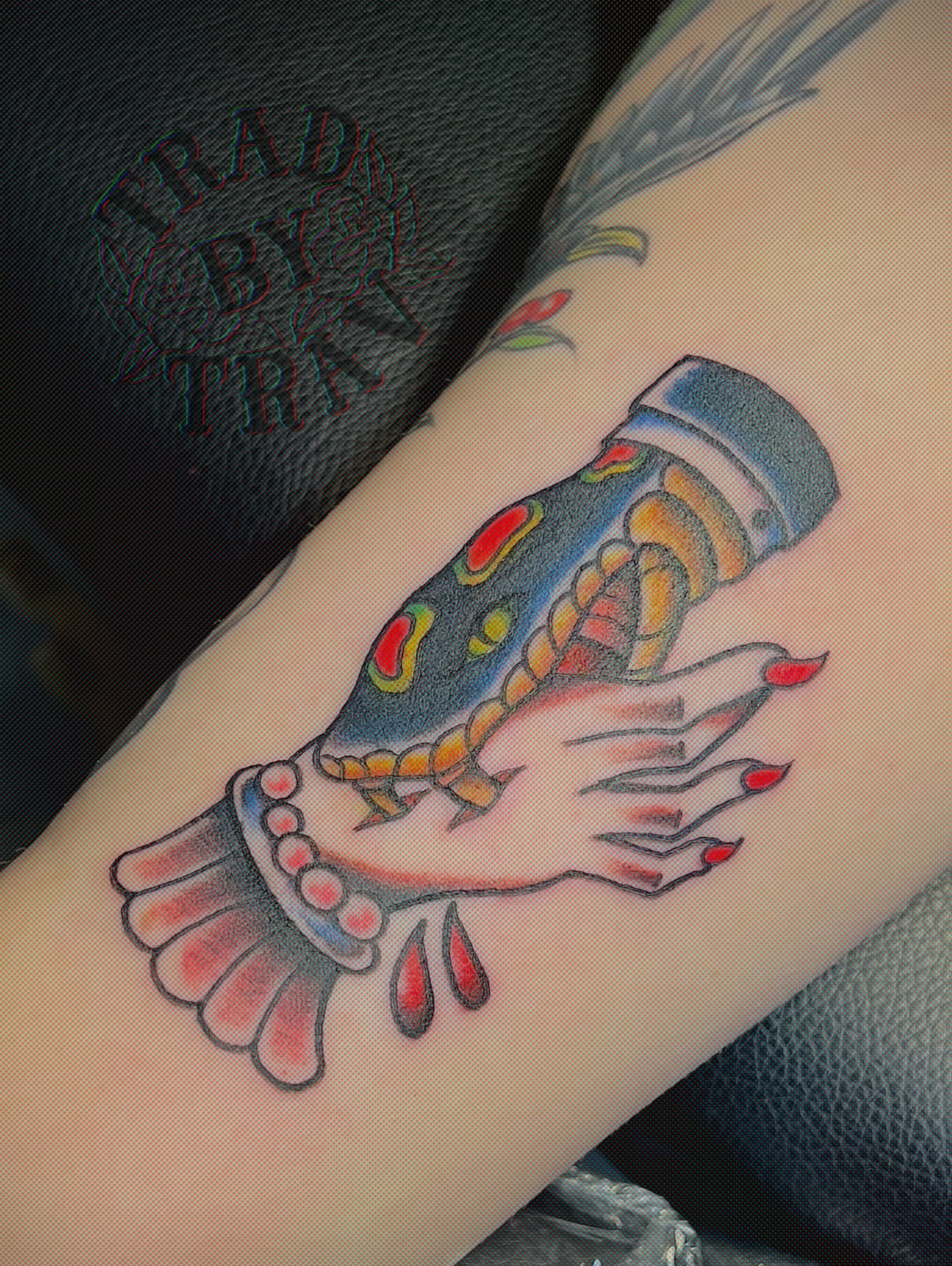 Hand holding bottle American traditional tattoo on the forearm by Travis B