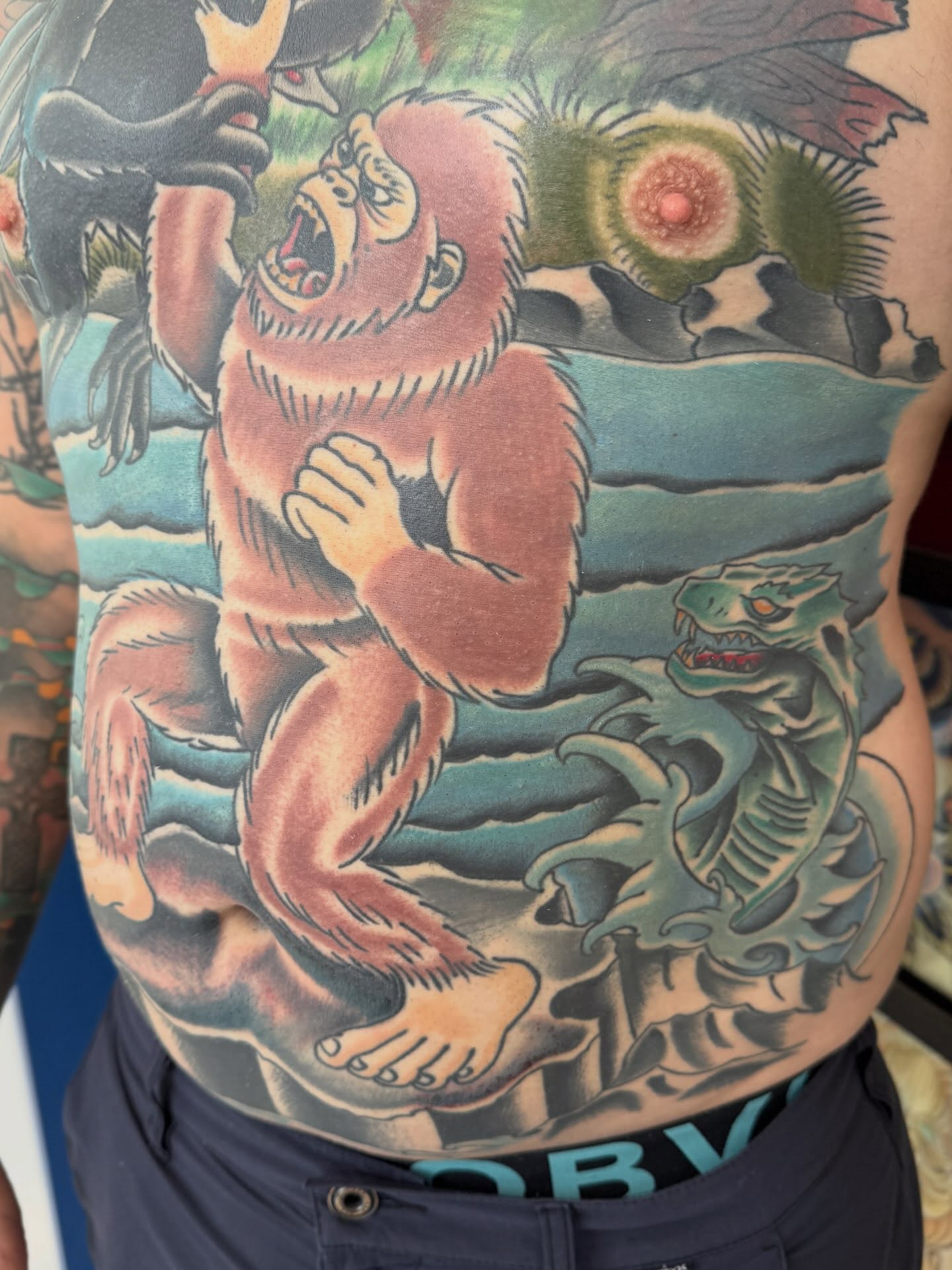 Gorilla and dragon American traditional tattoo on the torso by Trent Parsley