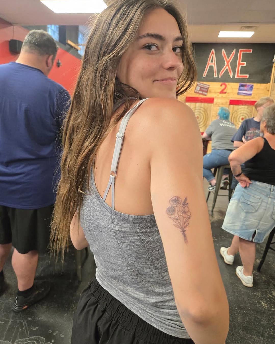 Flower bouquet black and grey tattoo on the upper arm by Malissa