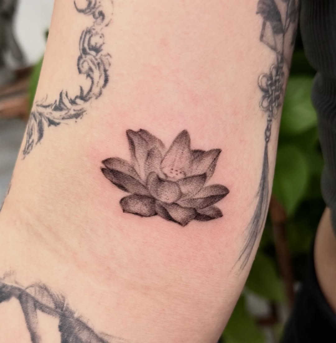 Lotus flower black and grey tattoo on the forearm by Xin Huang