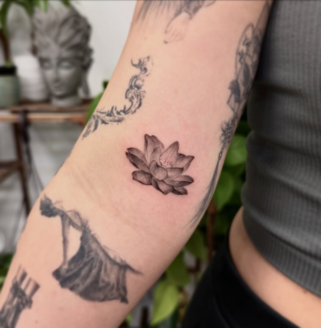 Lotus flower black and grey tattoo on the forearm by Xin Huang