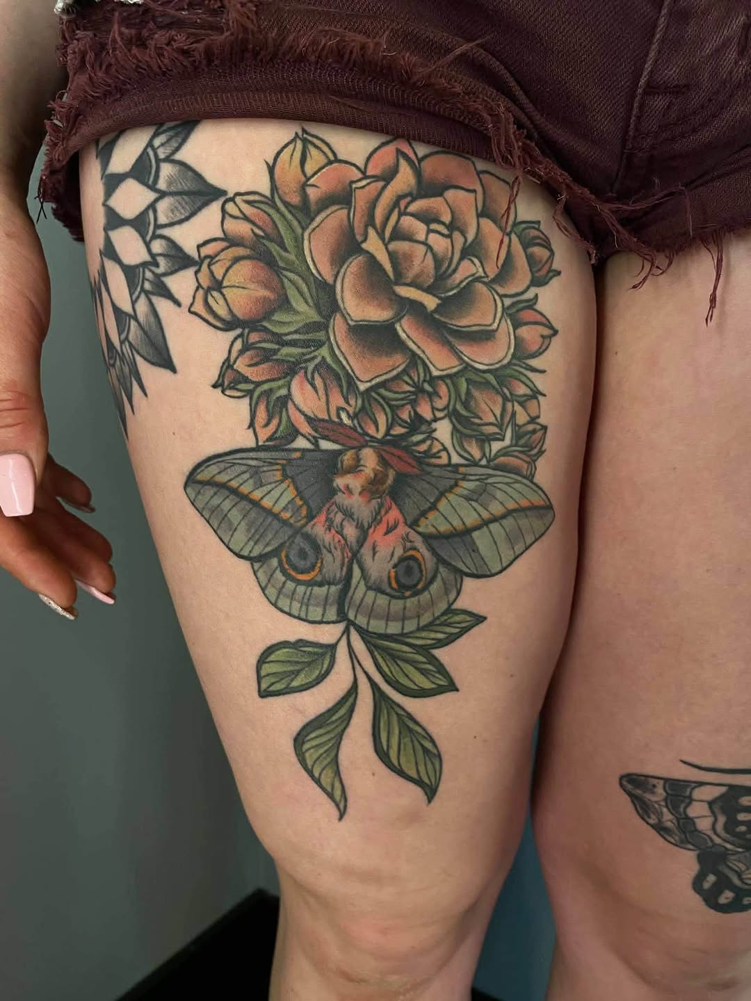 Moth and flowers neo-traditional tattoo on the thigh by Maddie Sutton