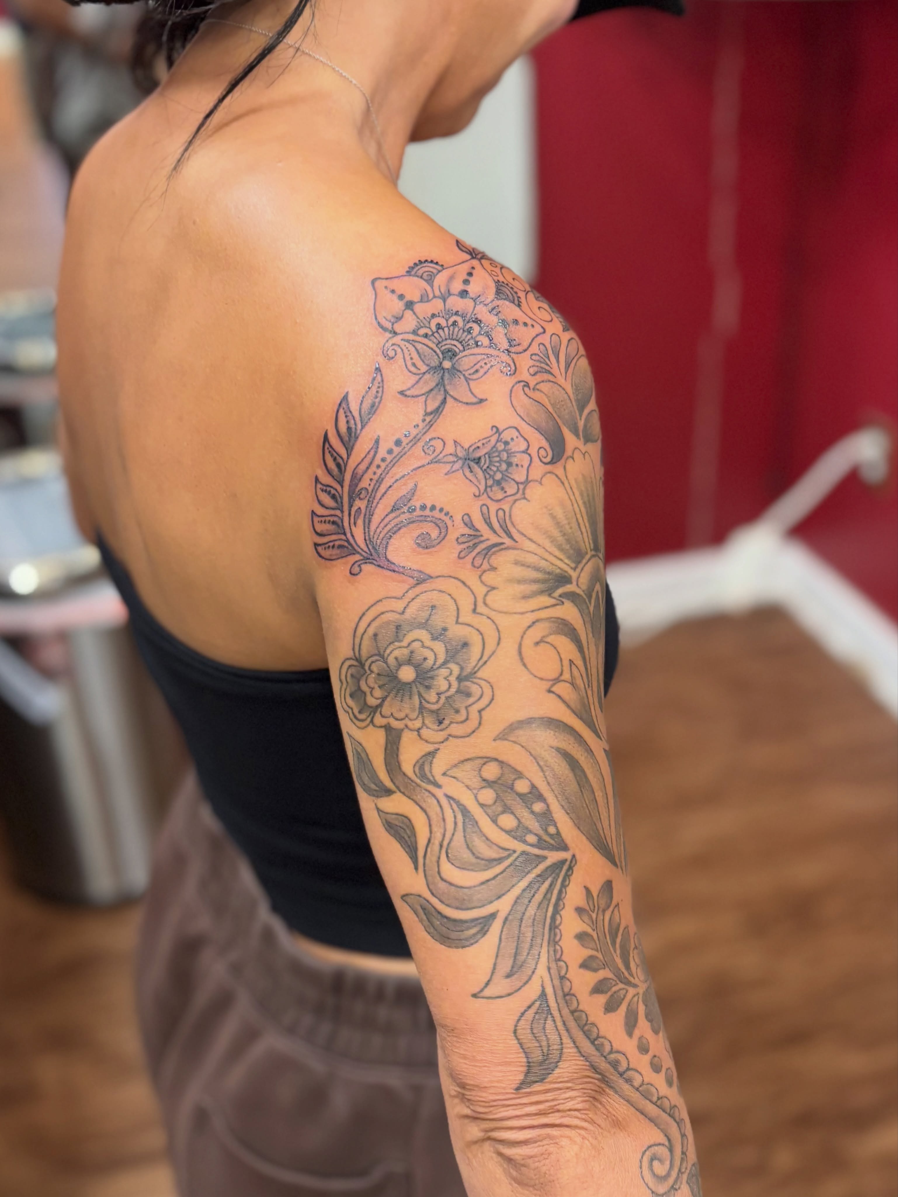 Floral design black and grey tattoo on the upper arm by Thom Johns-Green