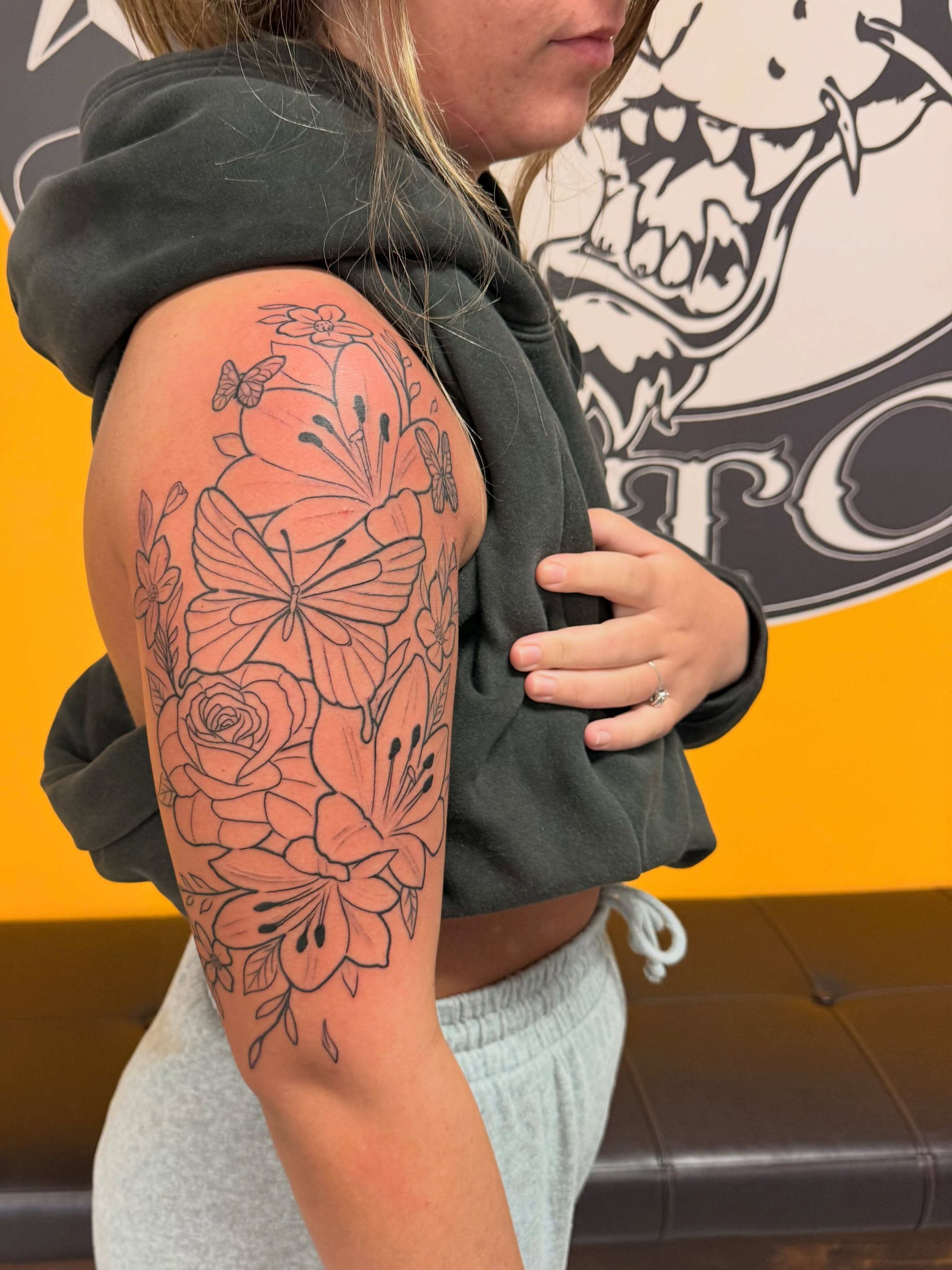 Floral arrangement black and grey tattoo on the upper arm by Frank Gomez 🎨