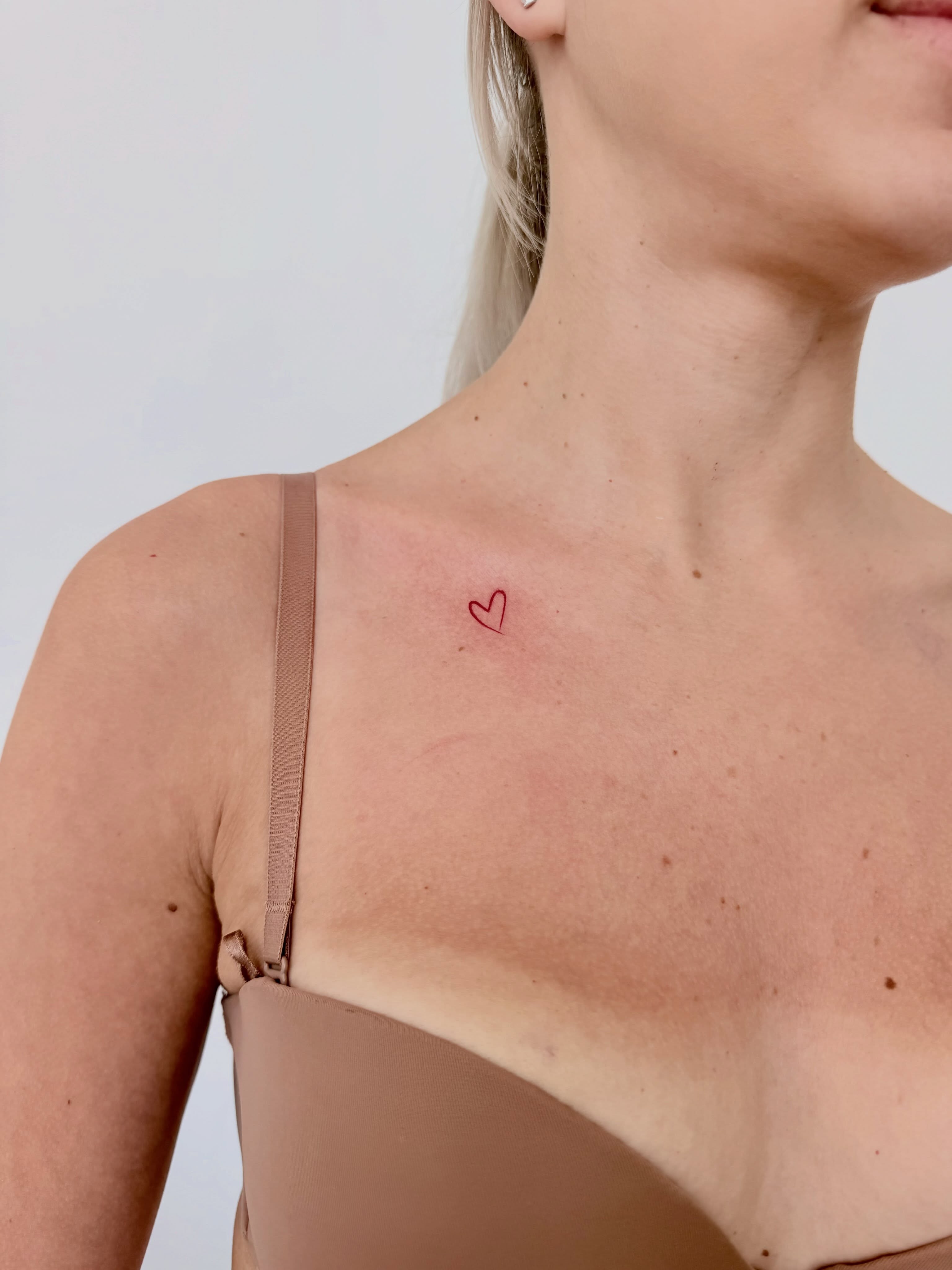 Heart minimalist tattoo on the chest by Fine Line Tattoo Artist