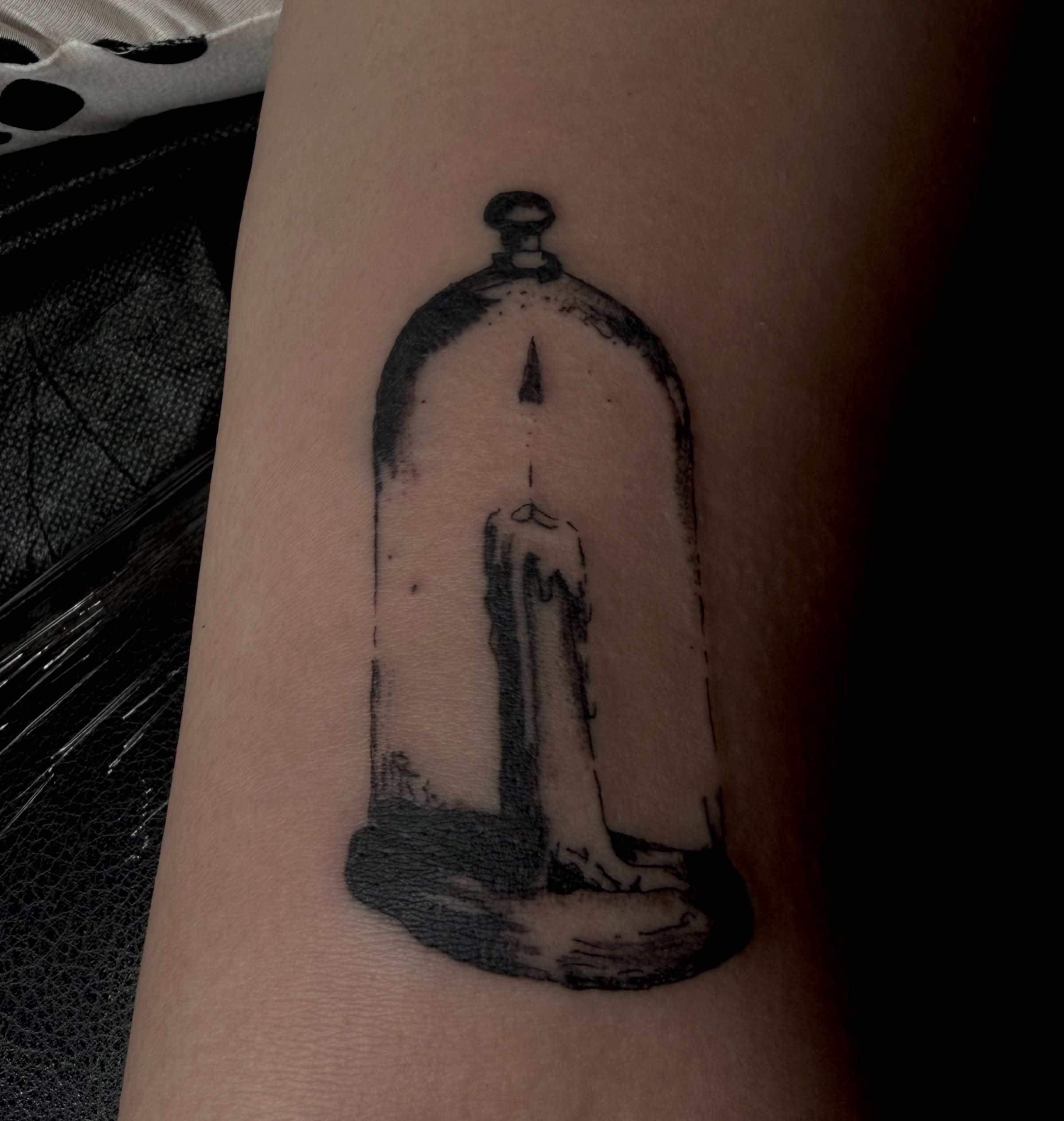 Candle under bell jar dotwork tattoo on the forearm by Jordan Sandoval
