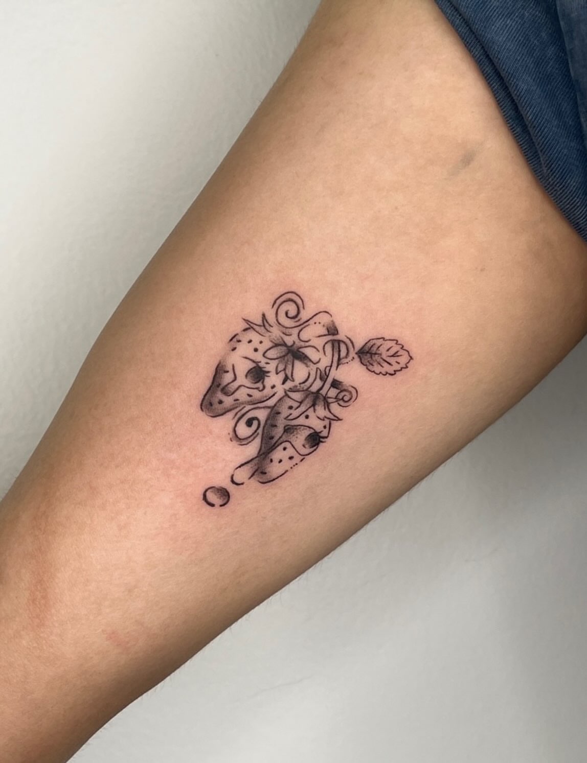 Lion and flower black and grey tattoo on the forearm by Elana Hites