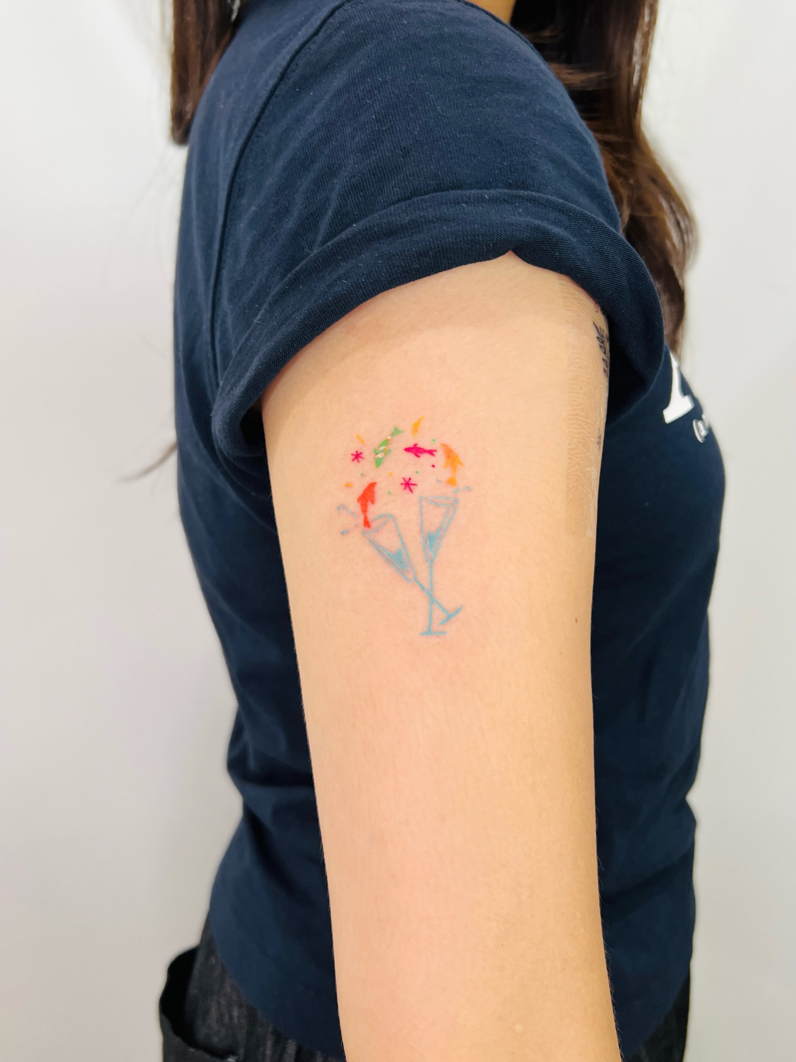 Champagne flutes watercolor tattoo on the forearm by Purinn