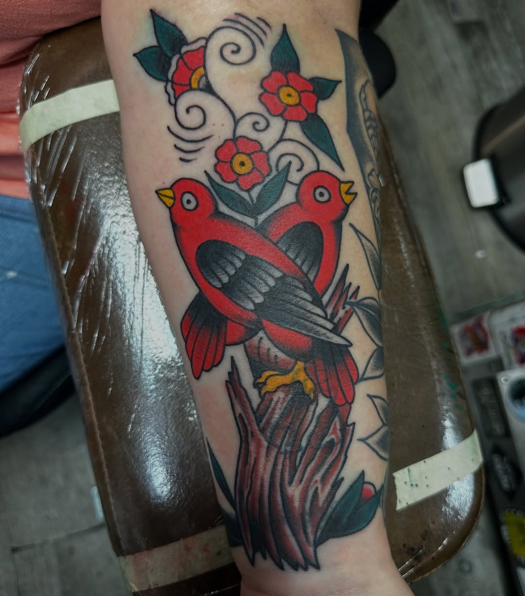 Red birds and flowers American traditional tattoo on the forearm by Devin Spenny