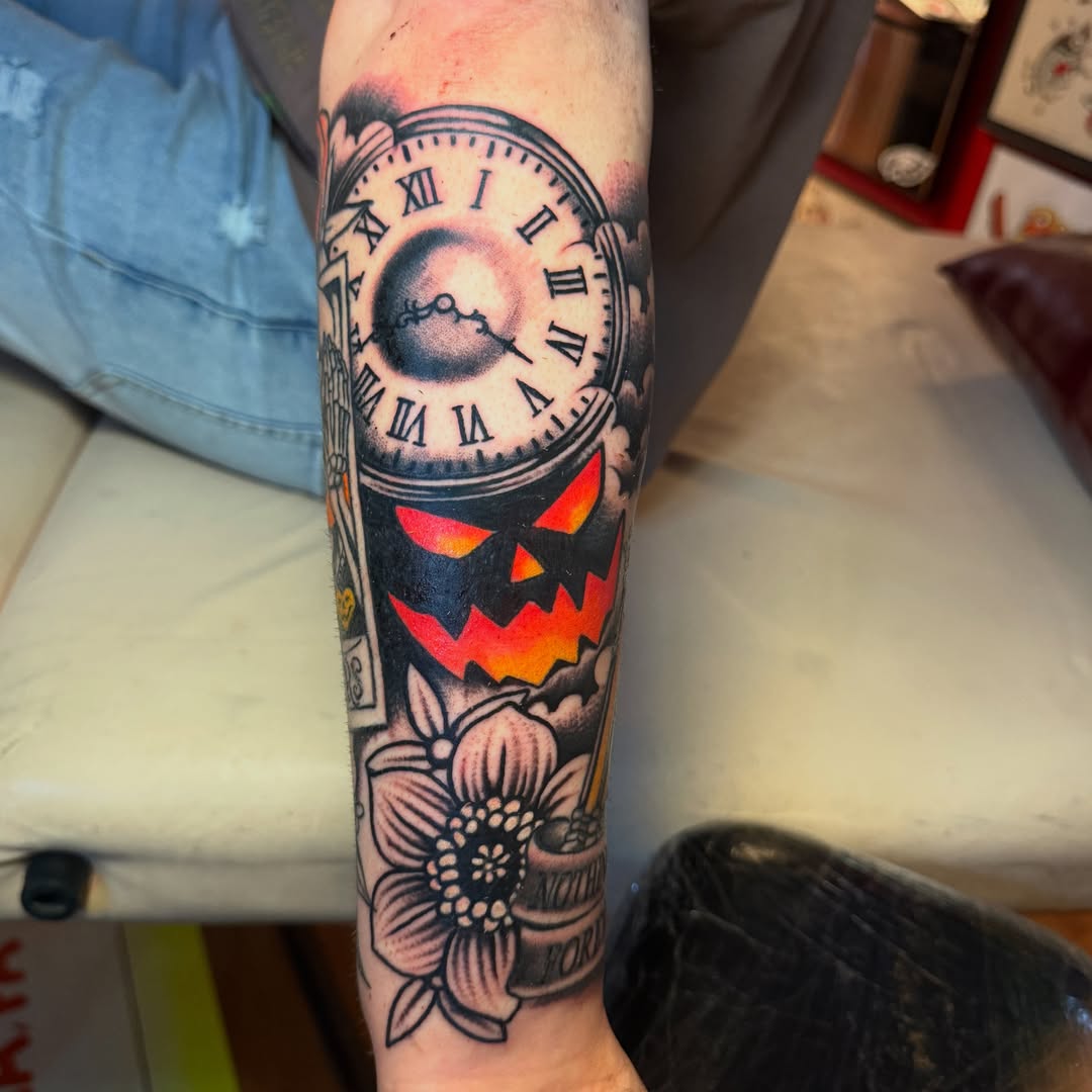 Clock with jack-o'-lantern American traditional tattoo on the forearm by Angus Perfect, Philadelphia, Pennsylvania