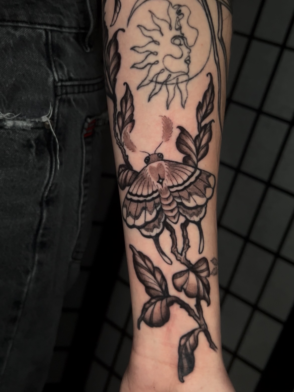 Butterfly and floral black and grey tattoo on the forearm by Vic Merkley