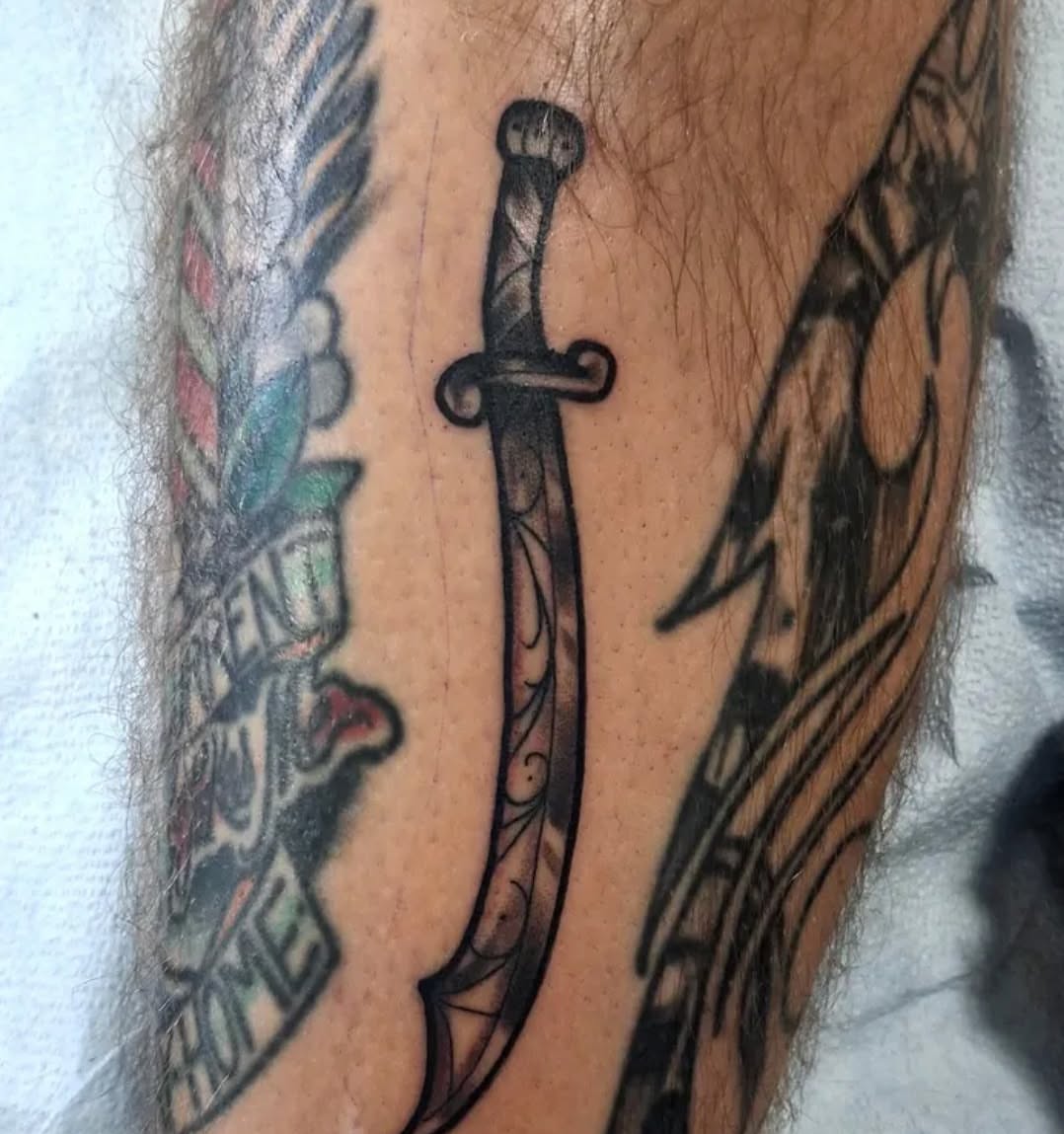 Sword black and grey tattoo on the forearm by Jake Mincey