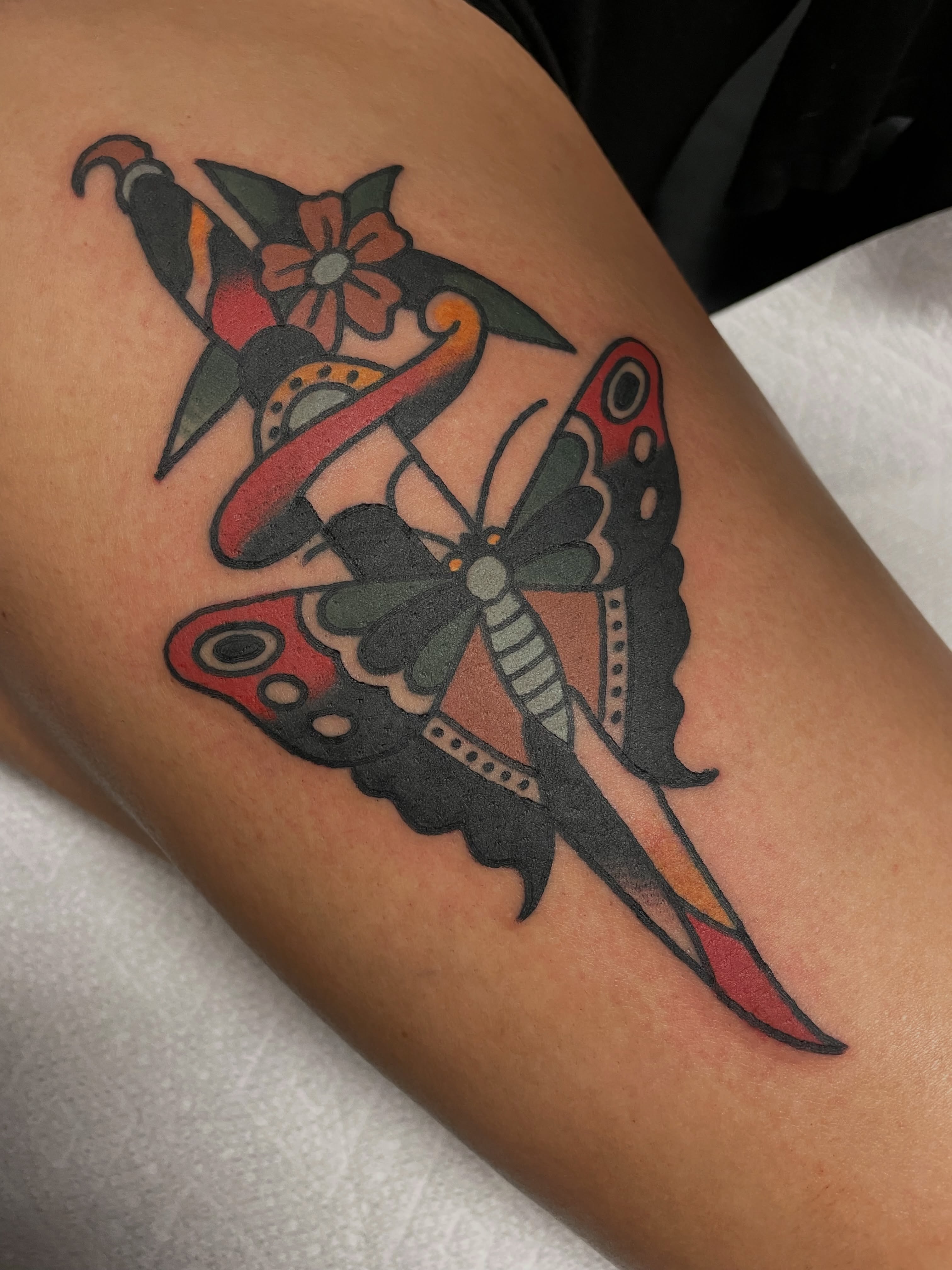 Butterfly and dagger American traditional tattoo on the thigh by @pizzabref