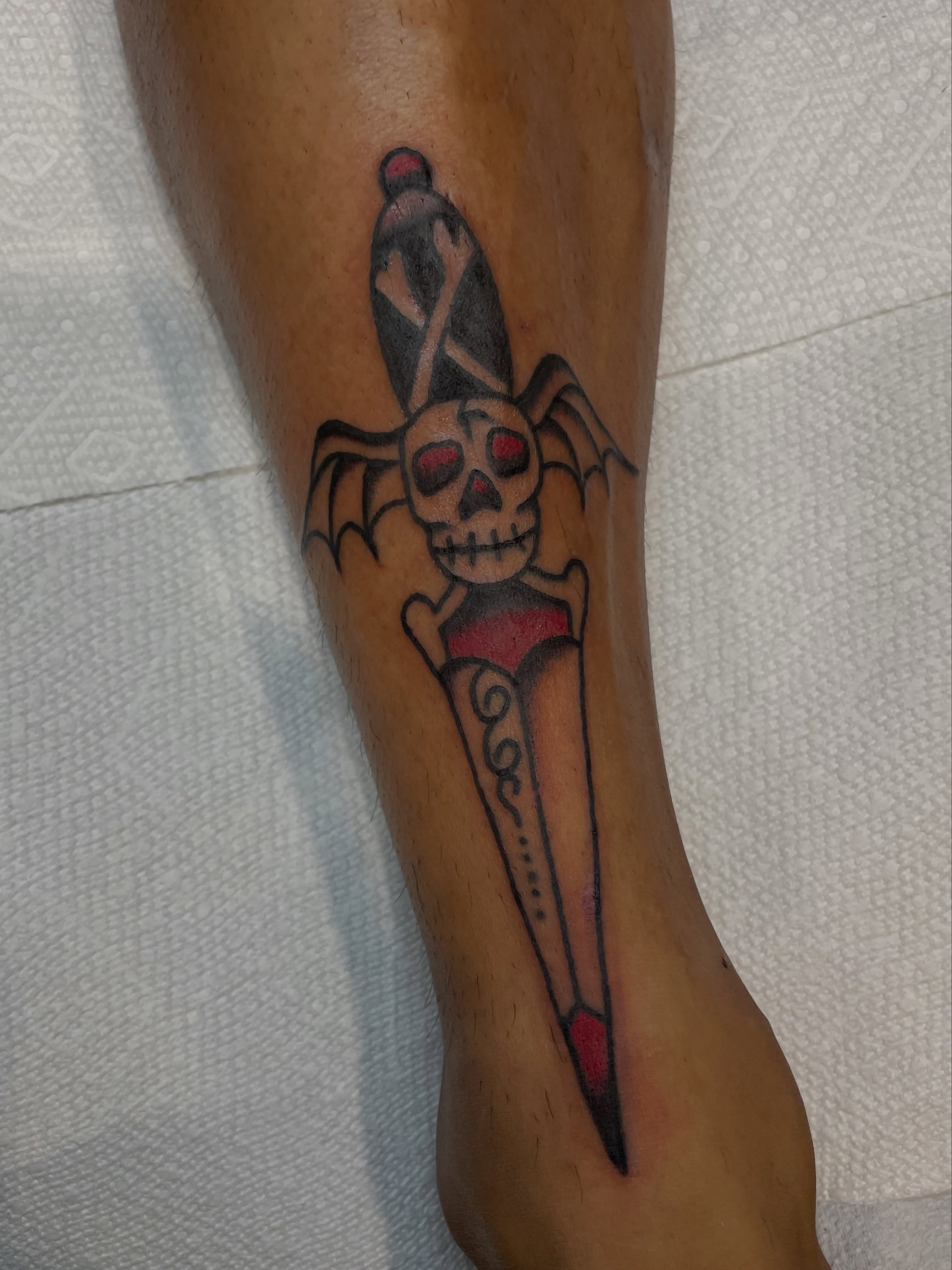Bat skull dagger American traditional tattoo on the forearm by Greg De Hoot, Youngsville, North Carolina