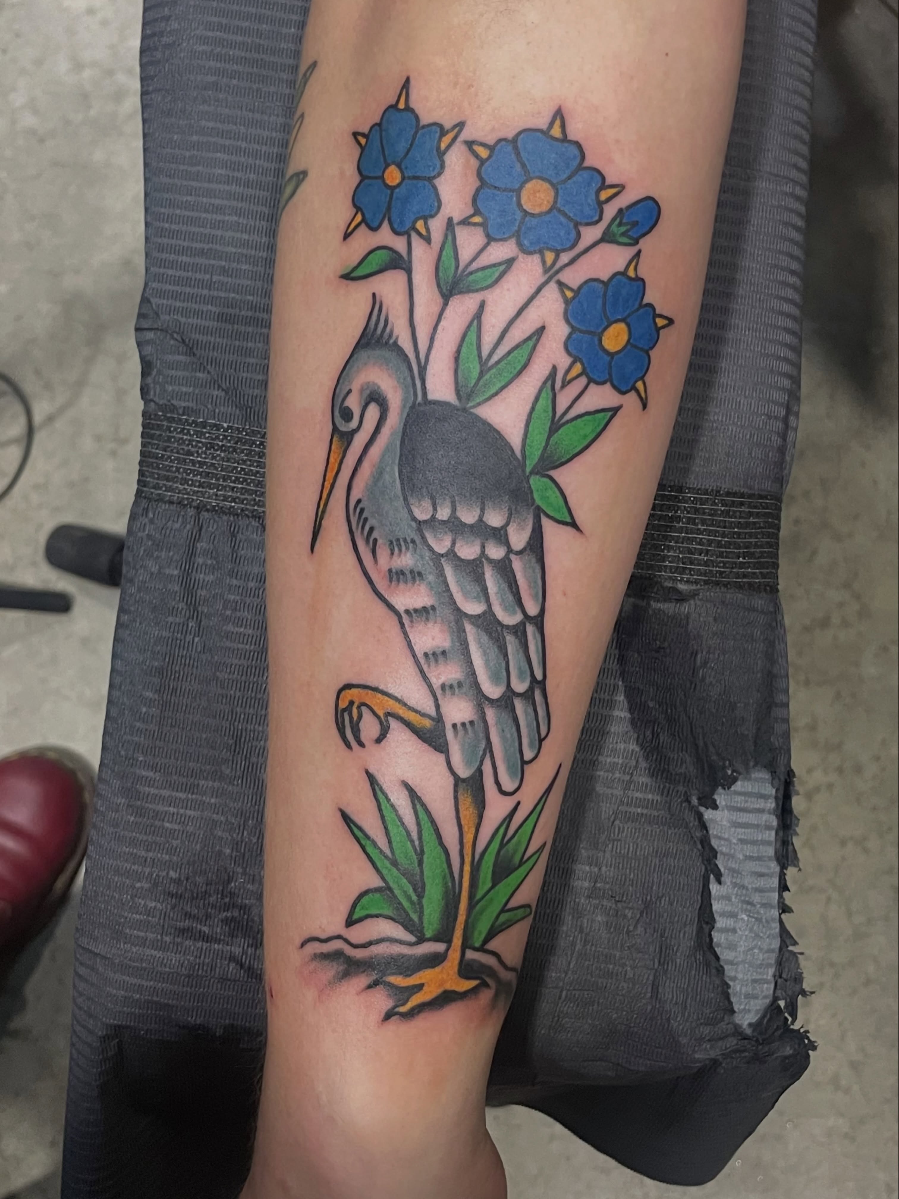 Heron and flowers American traditional tattoo on the forearm by Greg De Hoot, Youngsville, North Carolina