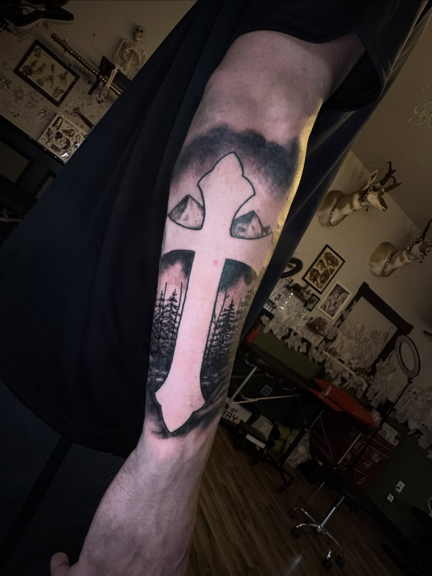 Cross with trees black and grey tattoo on the forearm by Mtctattoos