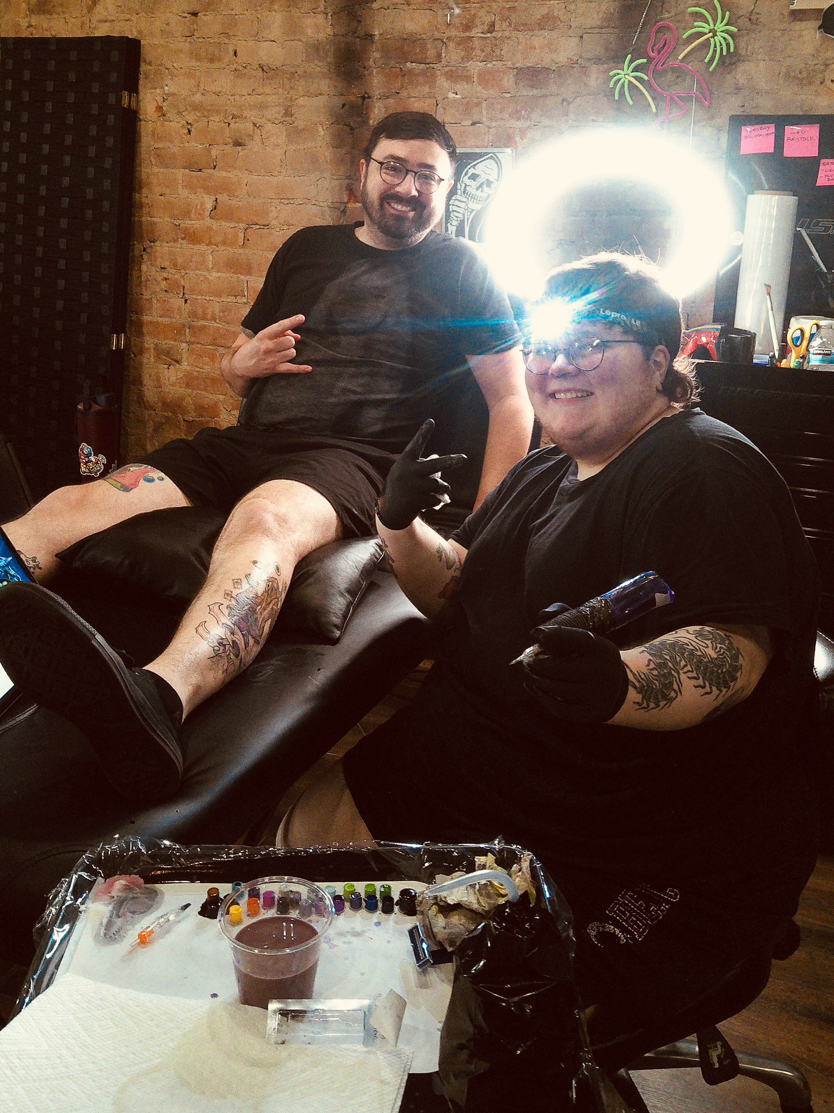 Tattoo artist and client American traditional tattoo on the thigh by Saint