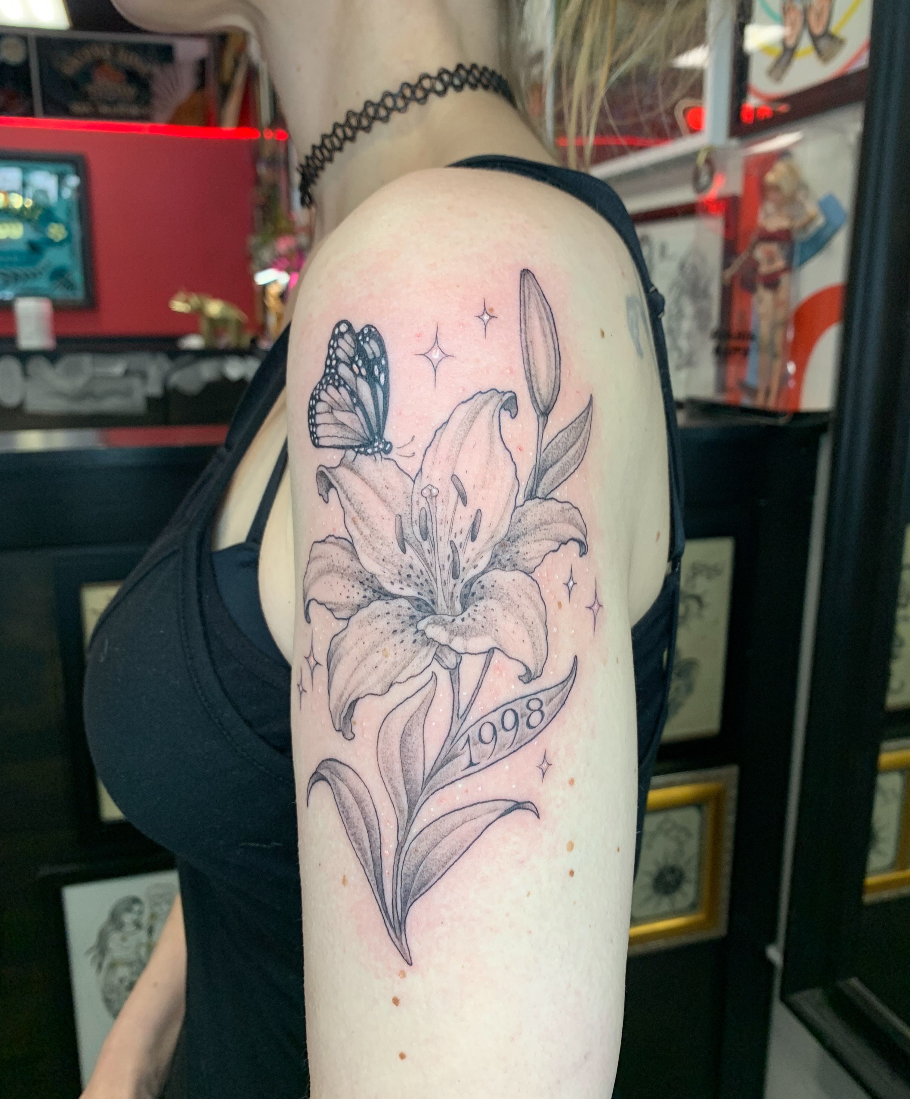 Lily and butterfly realism tattoo on the shoulder by Kitty Jones, Berkeley, California