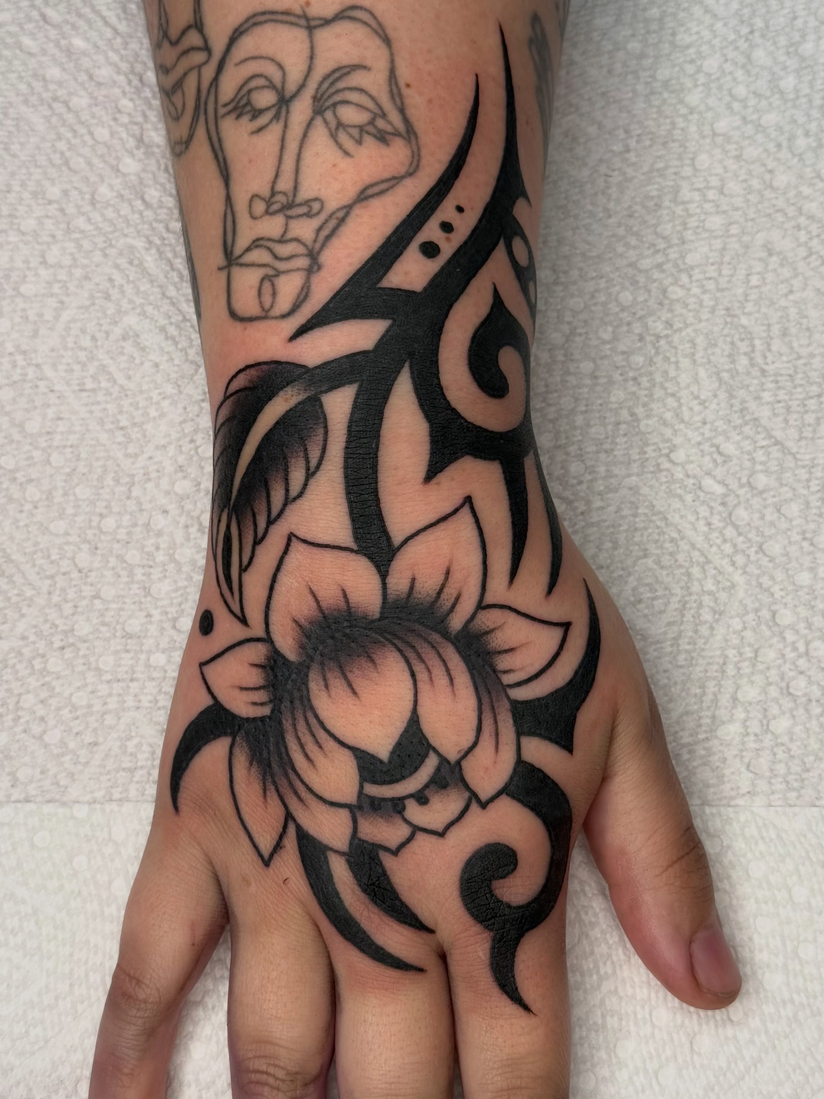 Lotus flower tribal tattoo on the hand by Emma Eaton