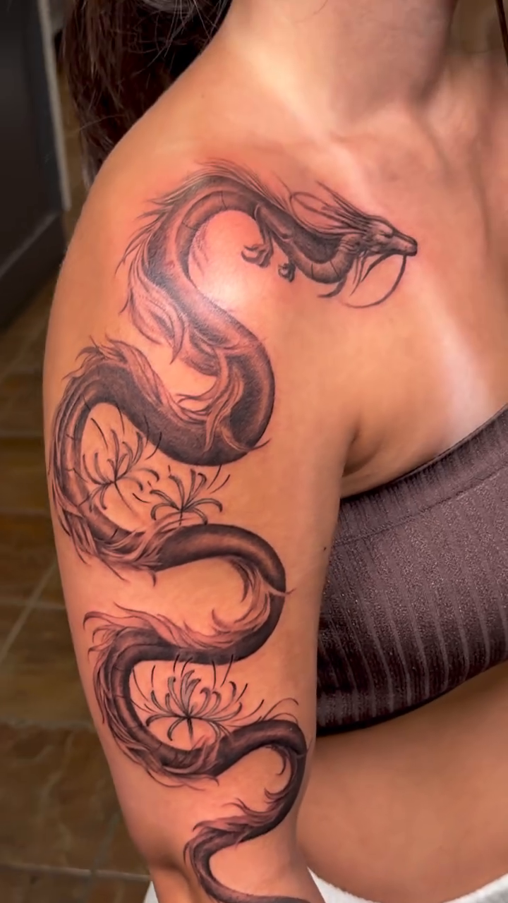 Dragon with skull and flowers watercolor tattoo on the shoulder by Tyler Vinson, Charlotte, North Carolina
