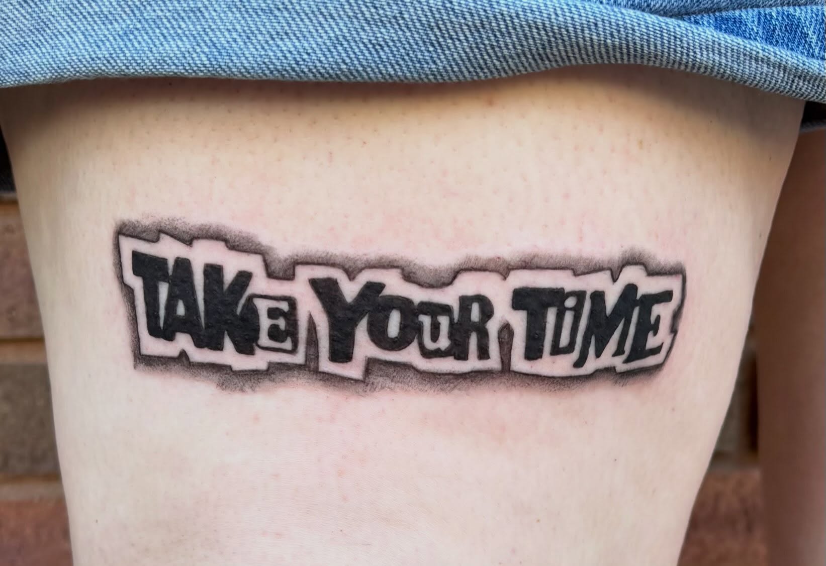 Take your time lettering script tattoo on the thigh by Sierra Maynard