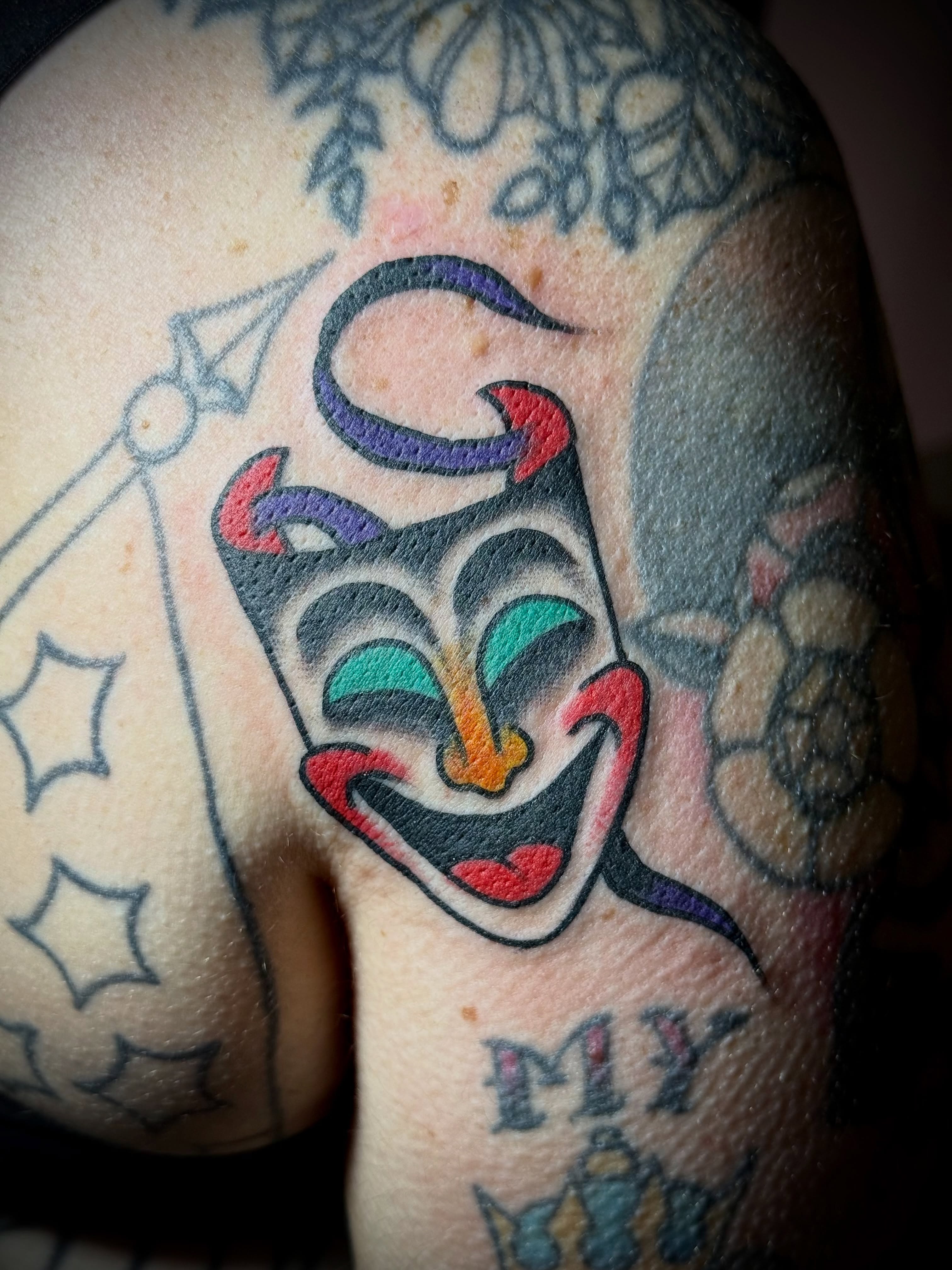 Joker mask American traditional tattoo on the forearm by Chuck Derek Whitaker