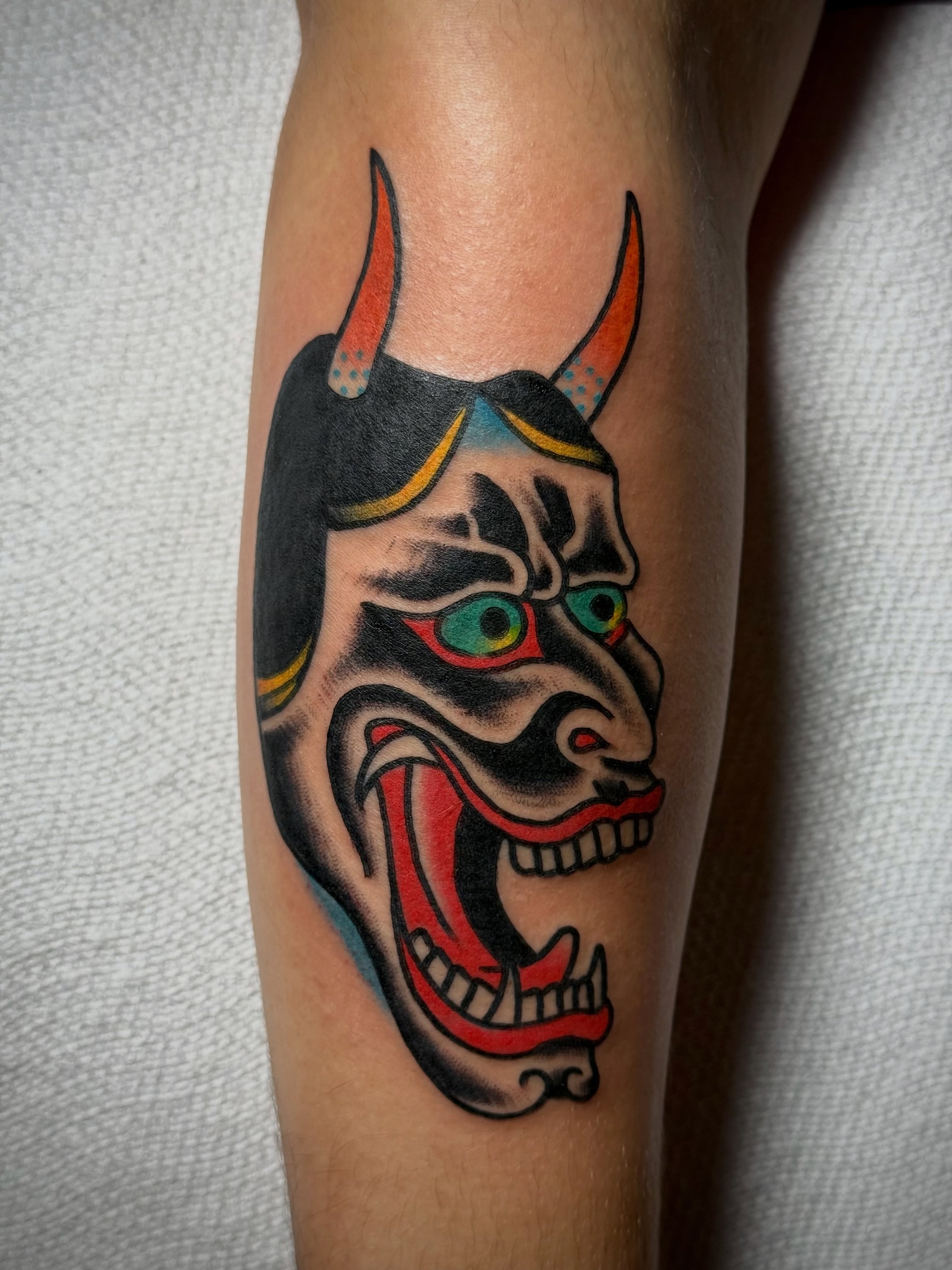 Demon mask American traditional tattoo on the forearm by Chuck Derek Whitaker
