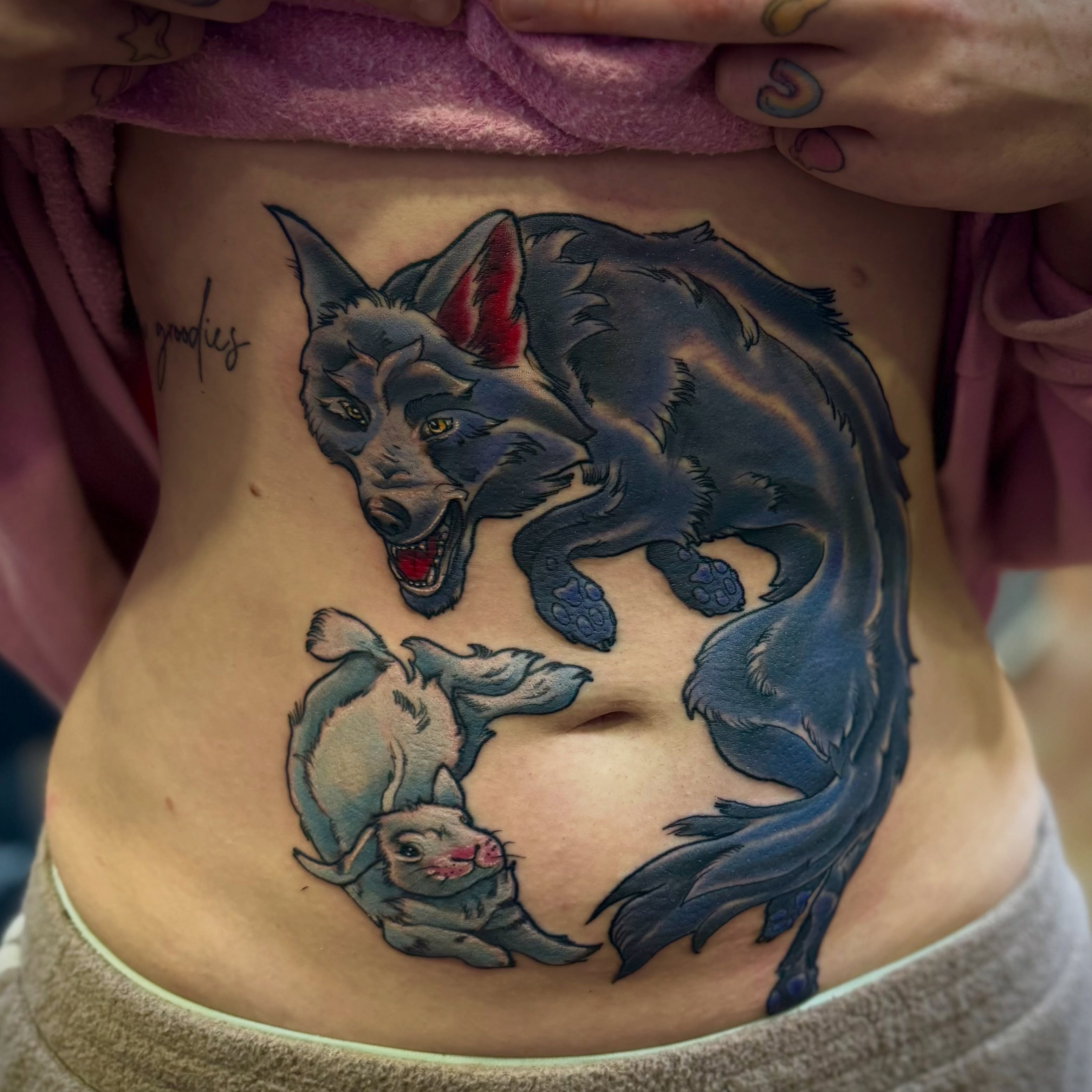 Wolf and rabbits realism tattoo on the ribs by David C. McGhee