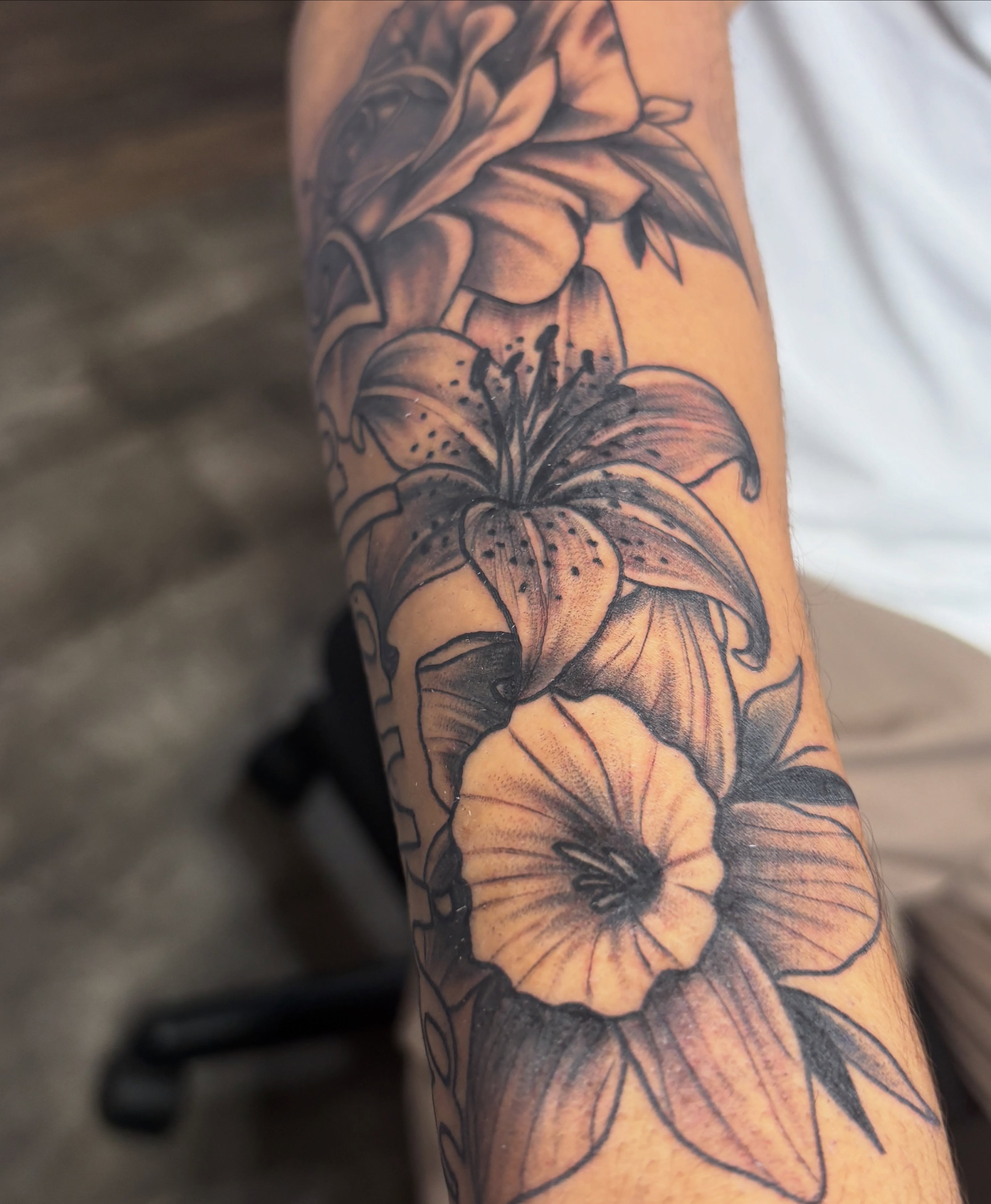 Lilies black and grey tattoo on the forearm by Casey - Tattooer, Salem, Massachusetts