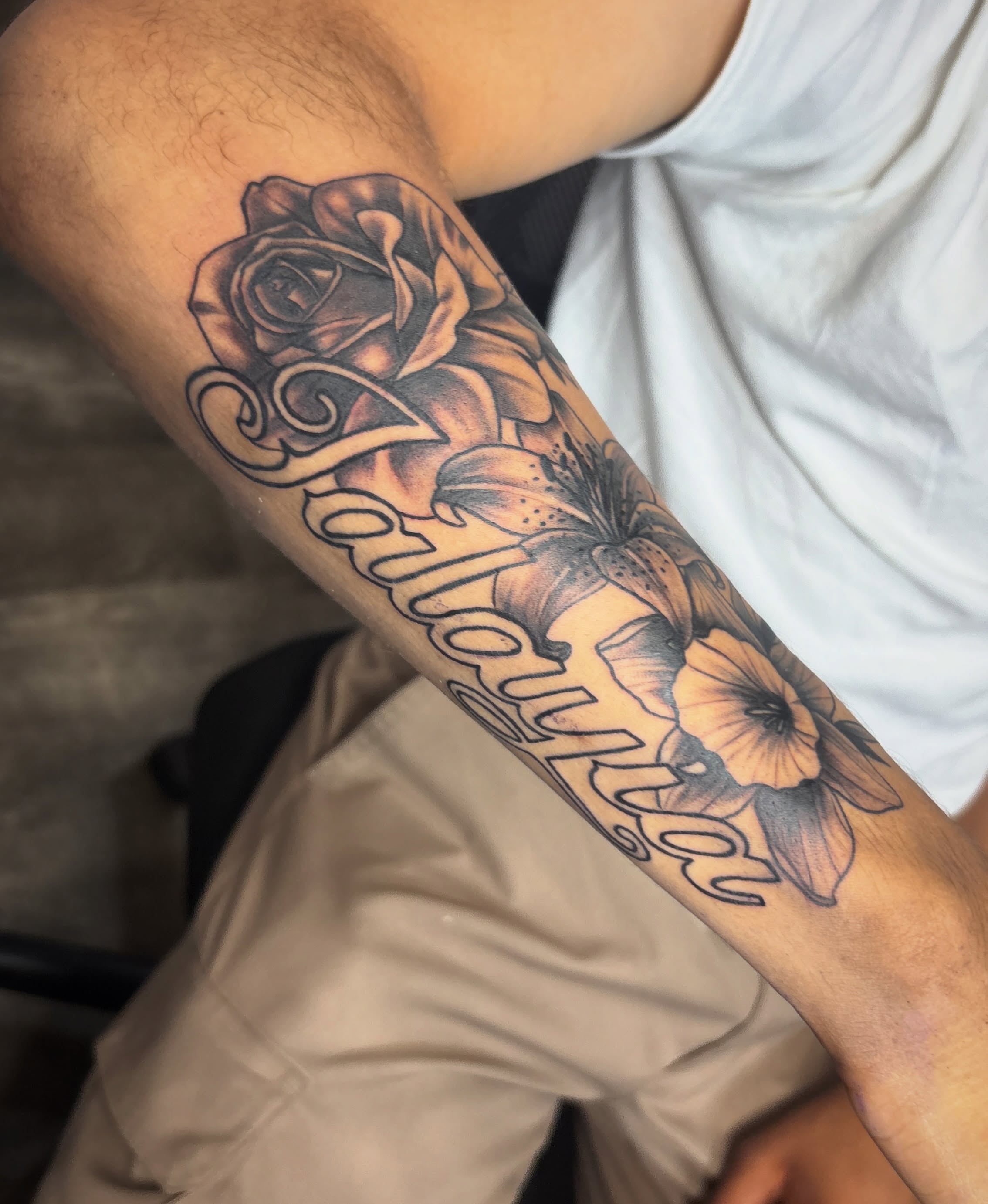 Rose and floral script realism tattoo on the forearm by Casey - Tattooer, Salem, Massachusetts