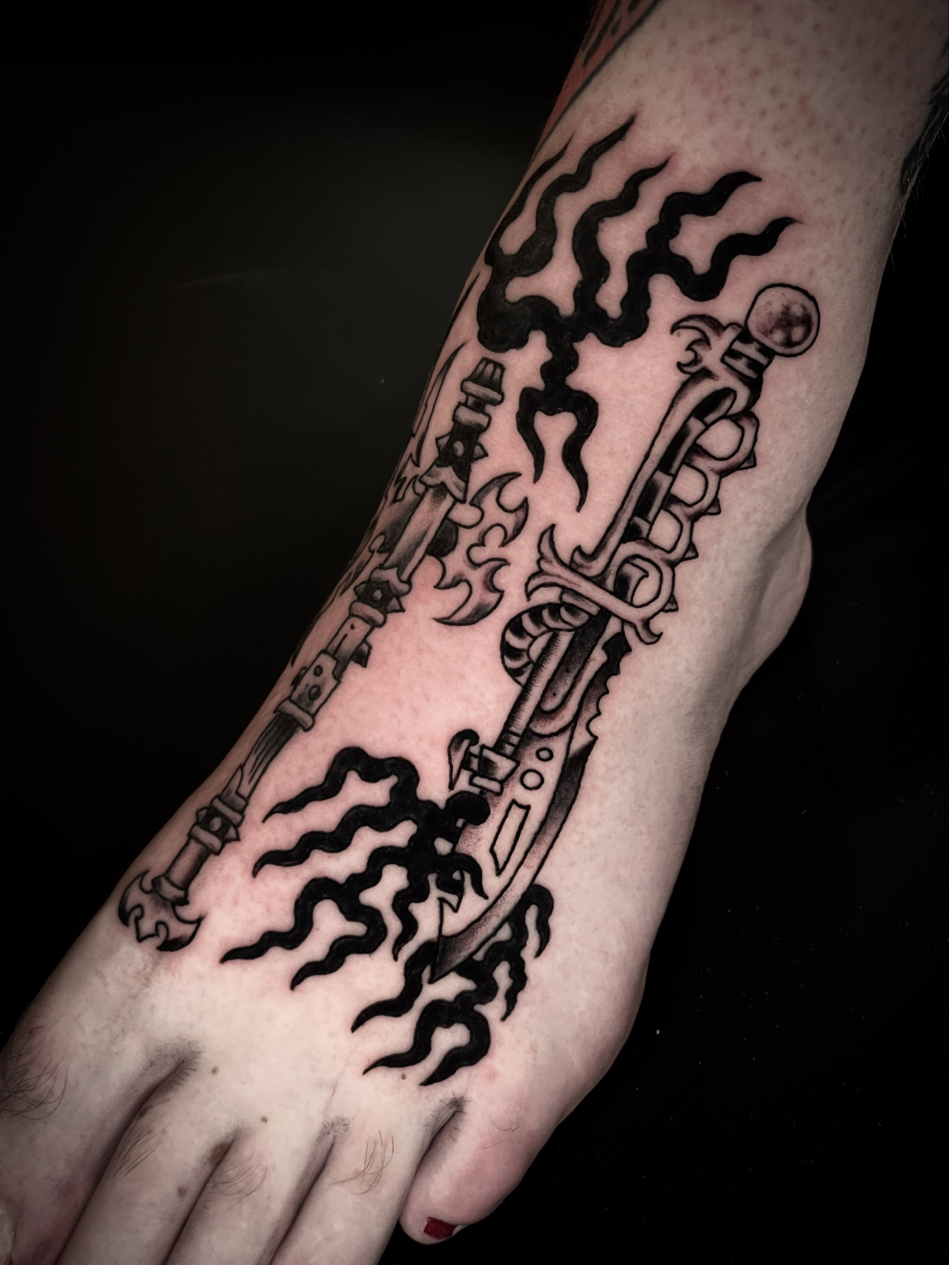 Sword and flames black and grey tattoo on the forearm by Nick Wallin