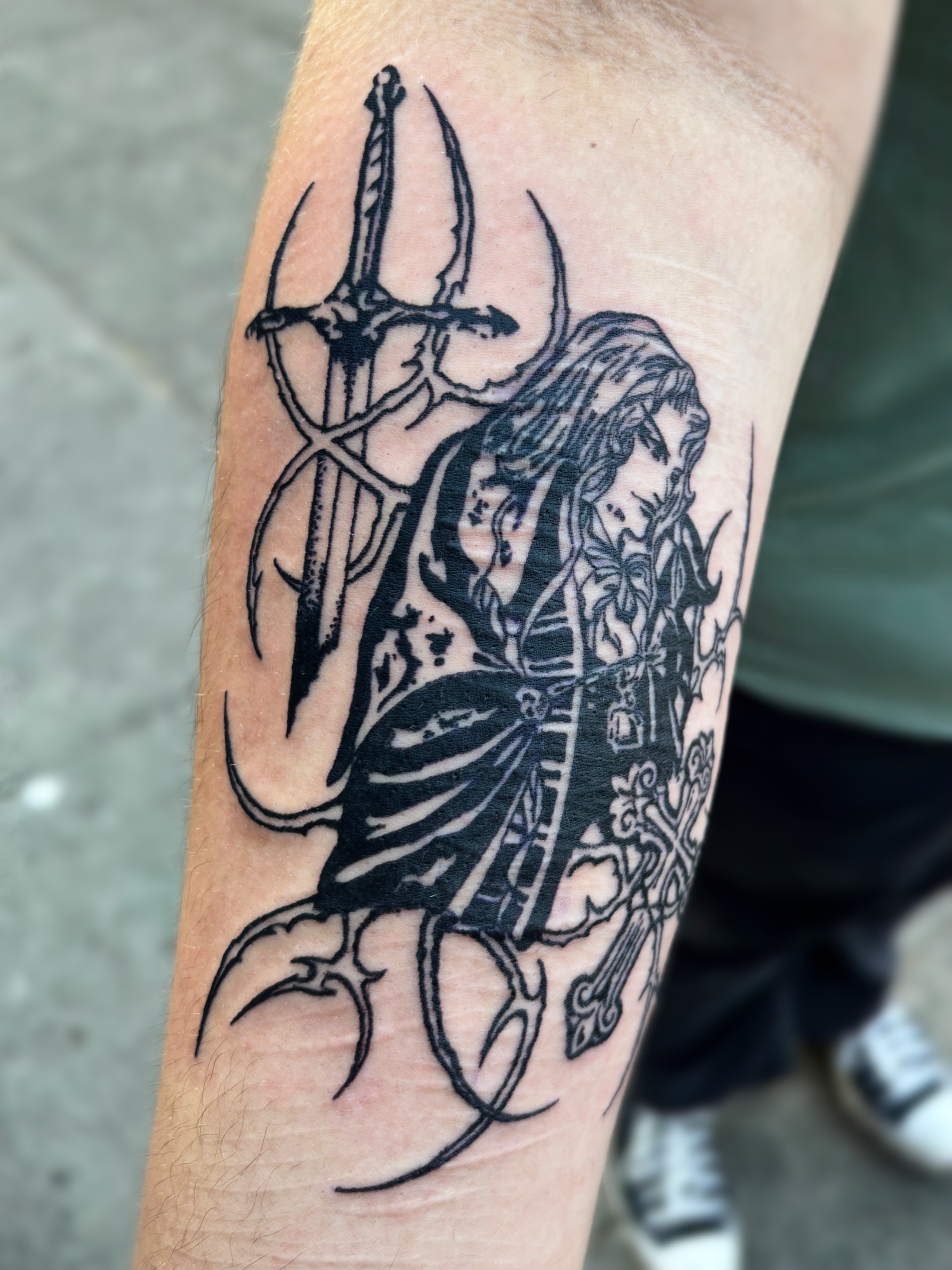Trident-wielding figure black and grey tattoo on the forearm by Cooper, Portland, Oregon