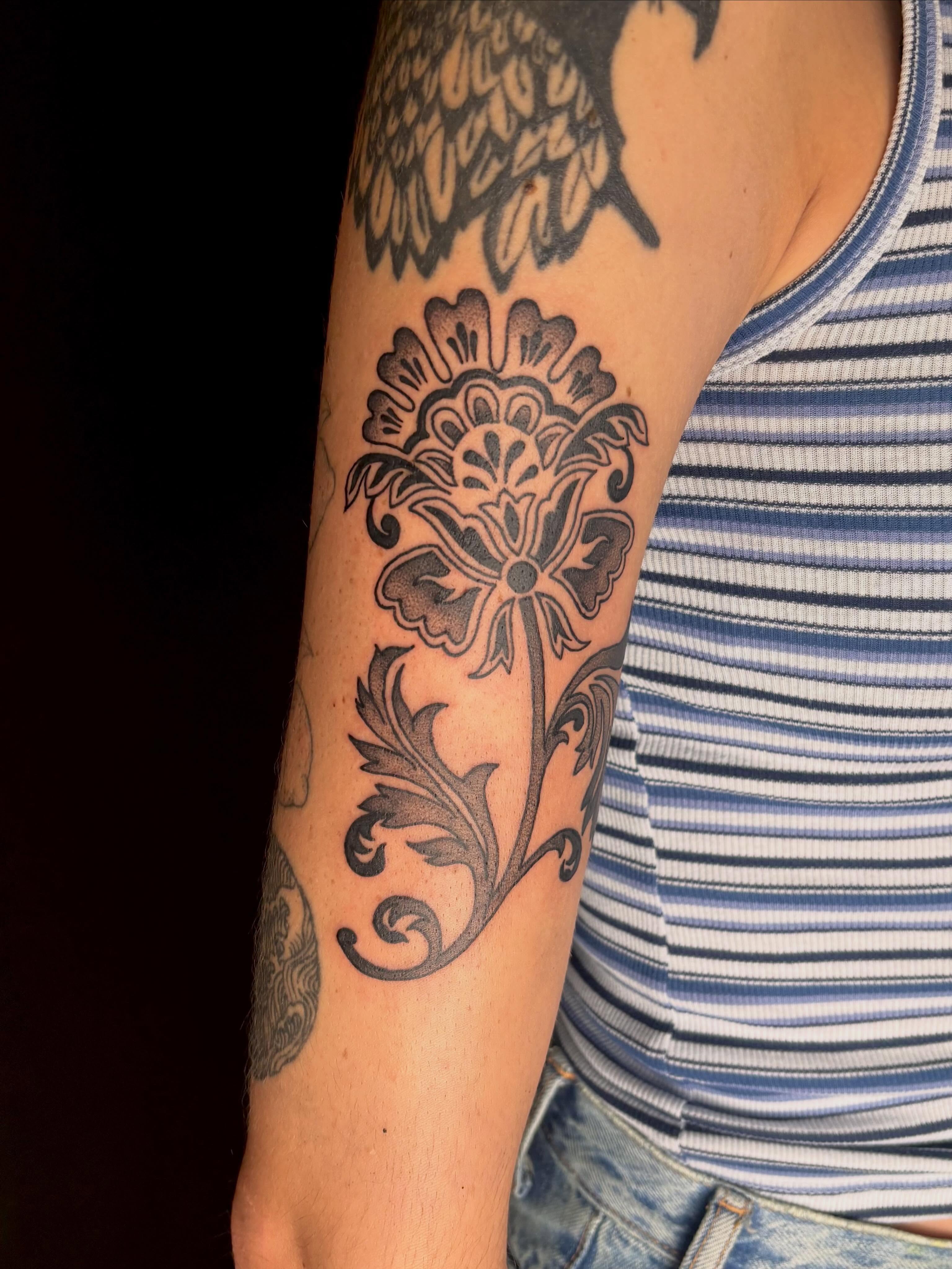 Floral design black and grey tattoo on the forearm by Erica McCullough