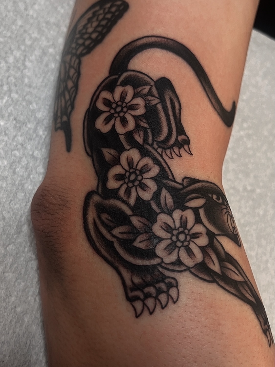 Snake and flowers black and grey tattoo on the forearm by Las Vegas Tattoo Artist