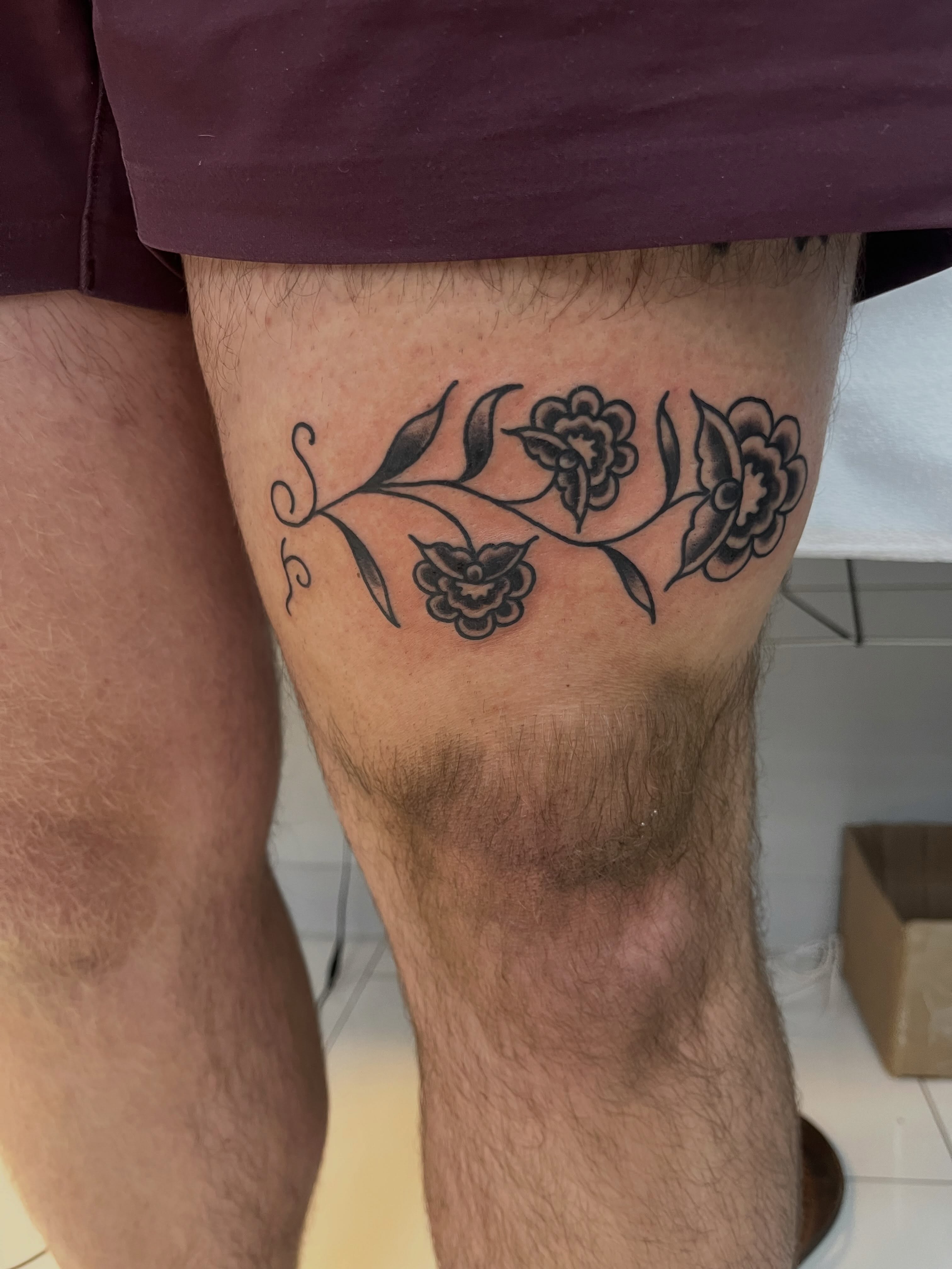 Floral vine black and grey tattoo on the thigh by Sour Tattoo, Somerville, Massachusetts