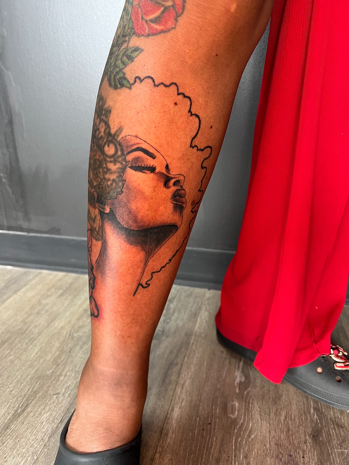 Woman with afro black and grey tattoo on the calf by Justx4rt