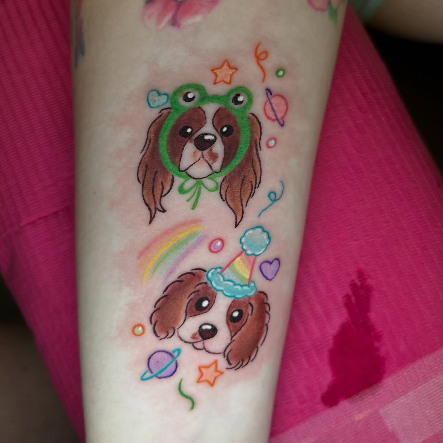 Dogs with accessories watercolor tattoo on the forearm by Ash Wheeler