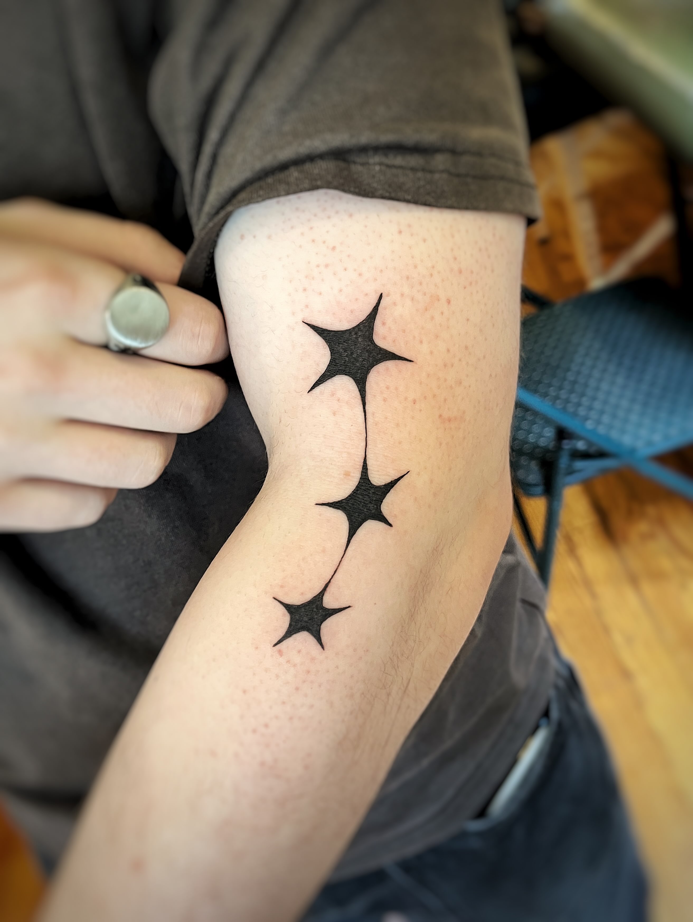 Stars black and grey tattoo on the forearm by Risa Cincinnati Tattoo Artist