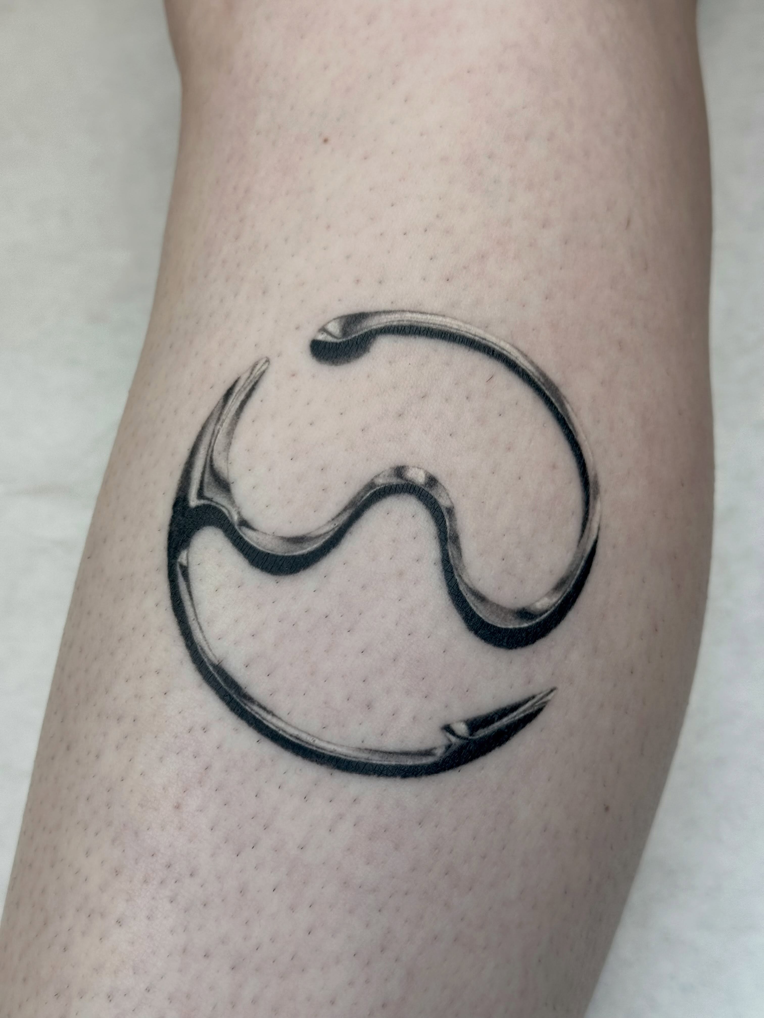 Abstract symbol black and grey tattoo on the forearm by Em Krieg