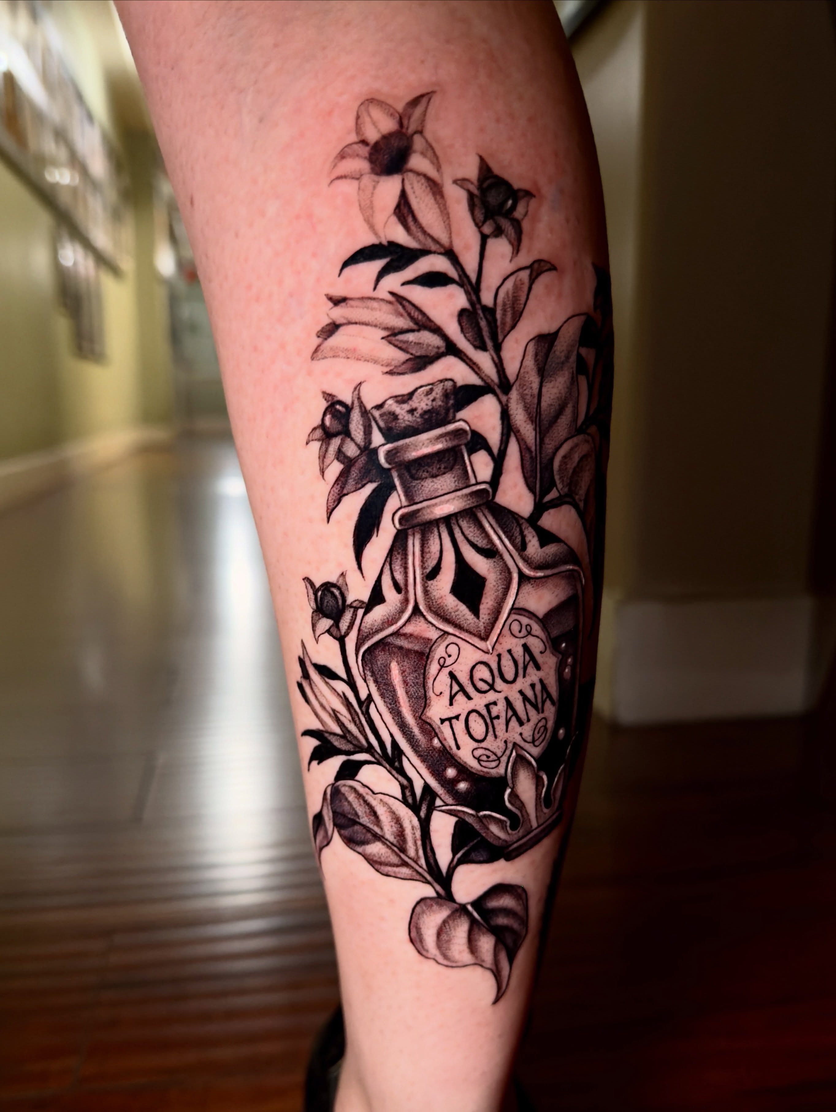 Poison bottle with flowers realism tattoo on the forearm by Marisa Biddle