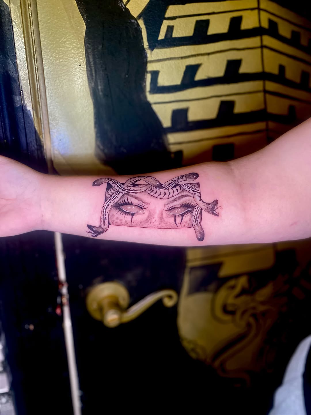 Medusa eyes and snakes realism tattoo on the forearm by Irving Guzman