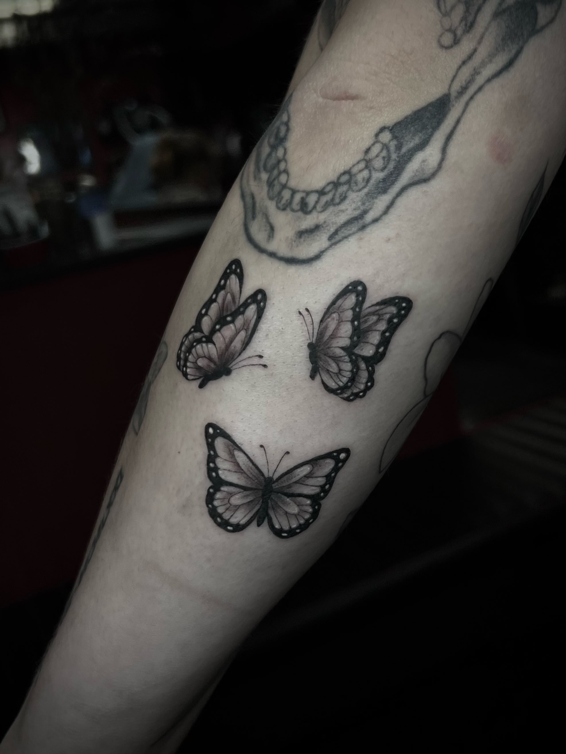 Butterflies black and grey tattoo on the forearm by Lexi Rose