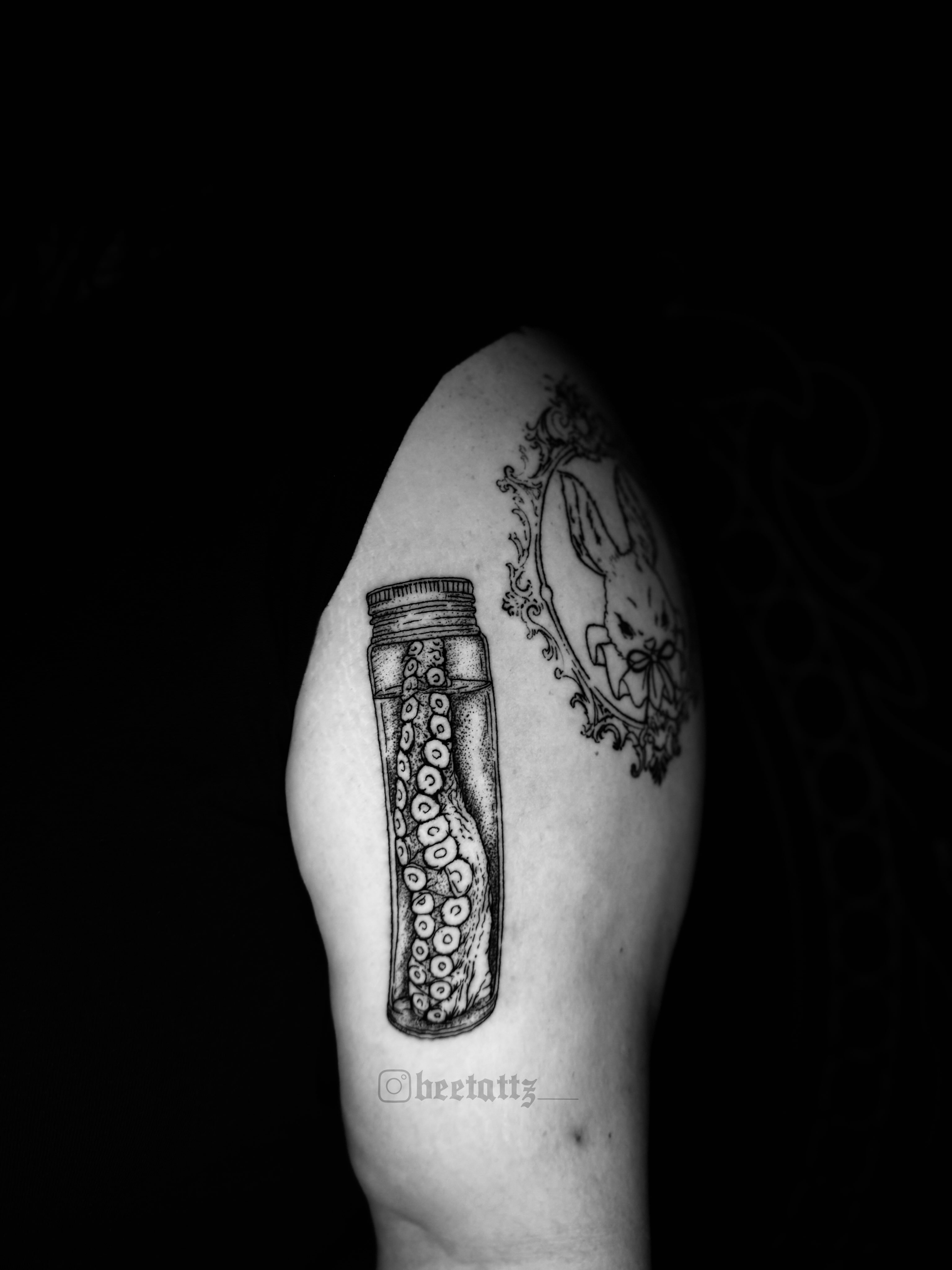 Octopus in jar black and grey tattoo on the shoulder by Brinkley McGill
