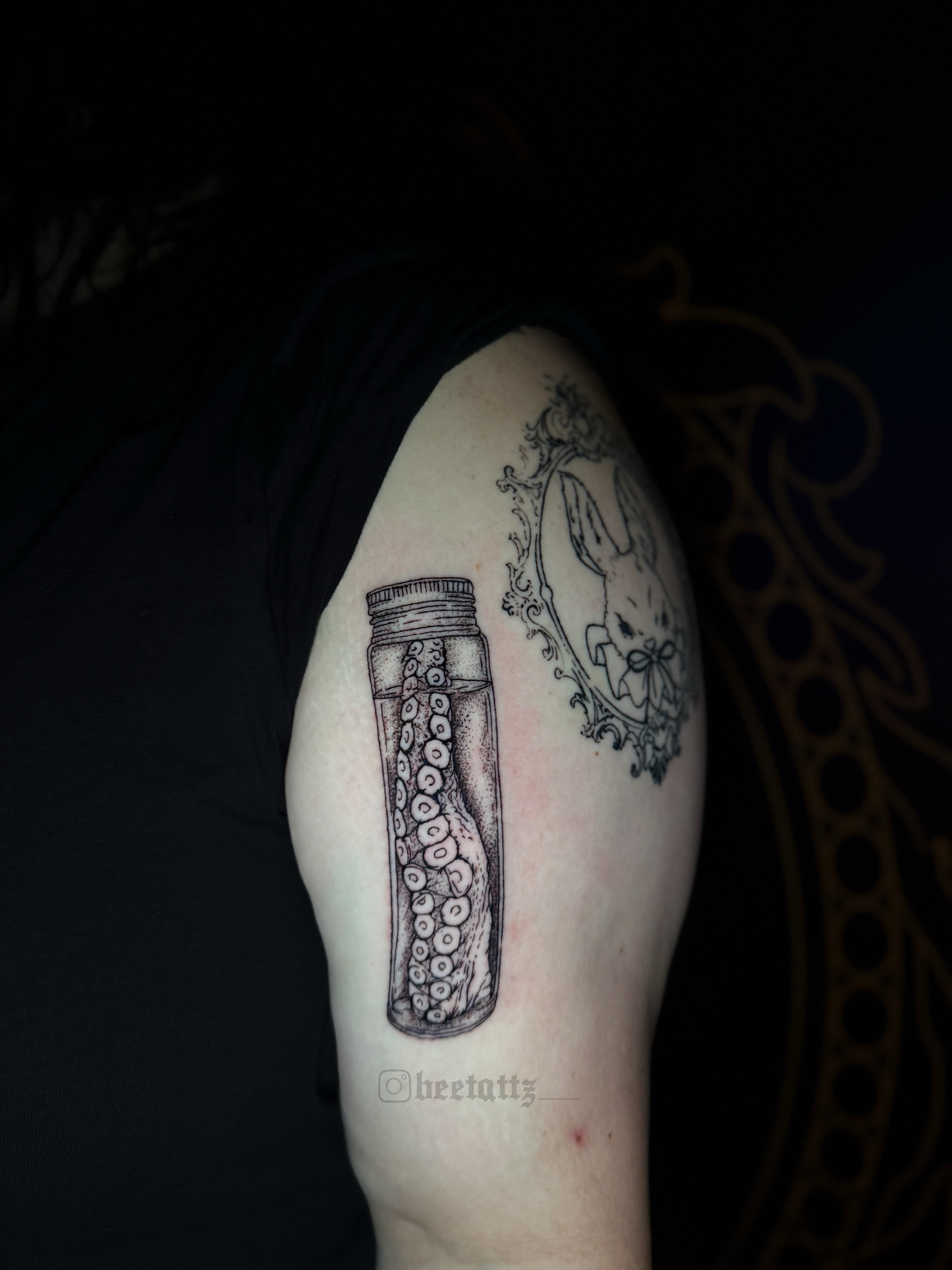 Octopus in jar black and grey tattoo on the shoulder by Brinkley McGill
