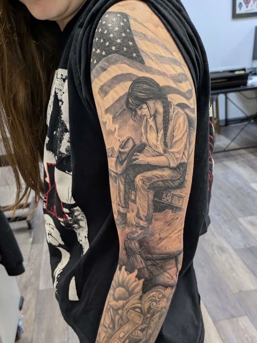 American flag and woman American traditional tattoo on the upper arm by Buddy K.