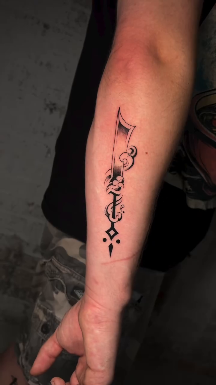 Ornamental sword fine line tattoo by Musa Selman