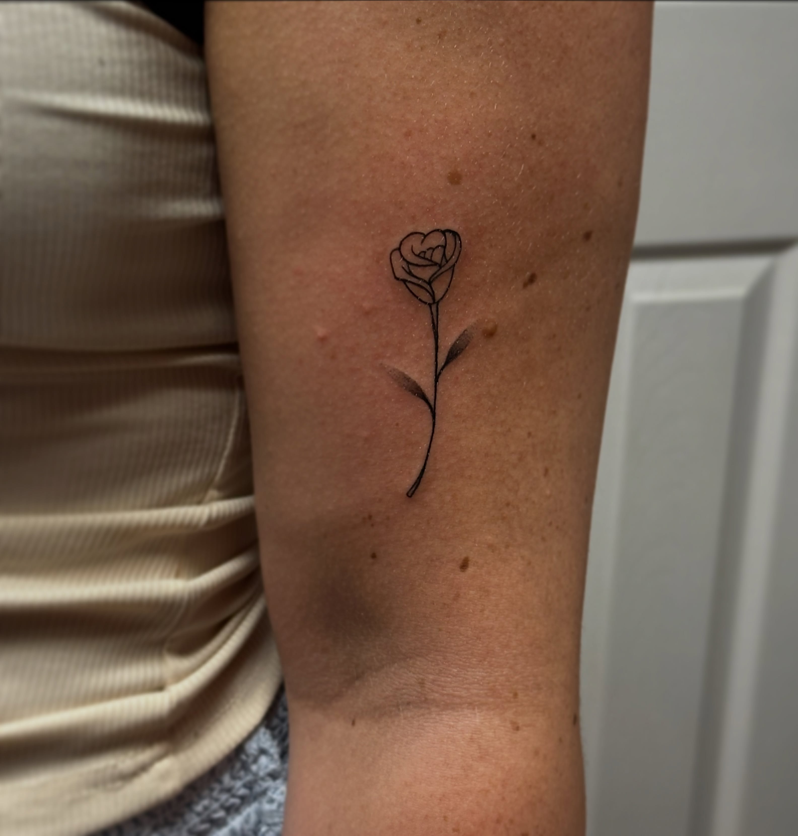 Rose minimalist tattoo on the forearm by Jocelyn
